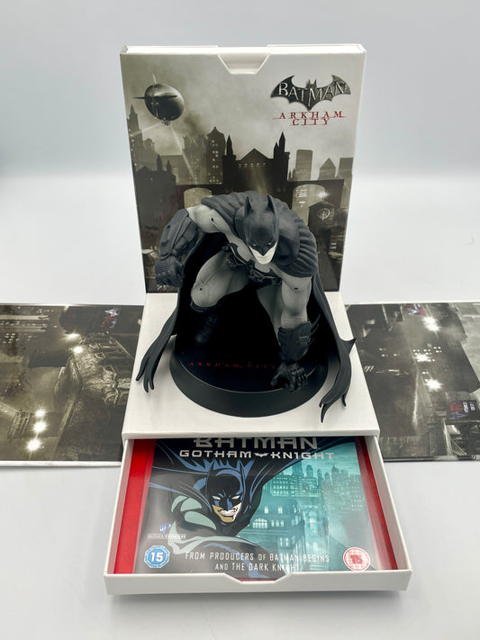 Batman figurine in a display box with 'Batman: Arkham City' and 'Batman: Gotham Knight' branding.