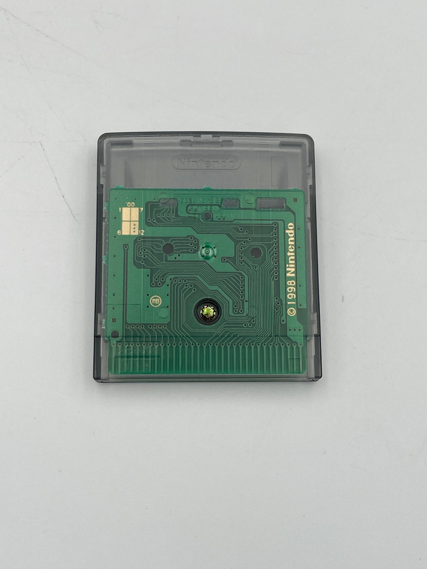 Green electronic circuit board in a clear casing on a light gray background