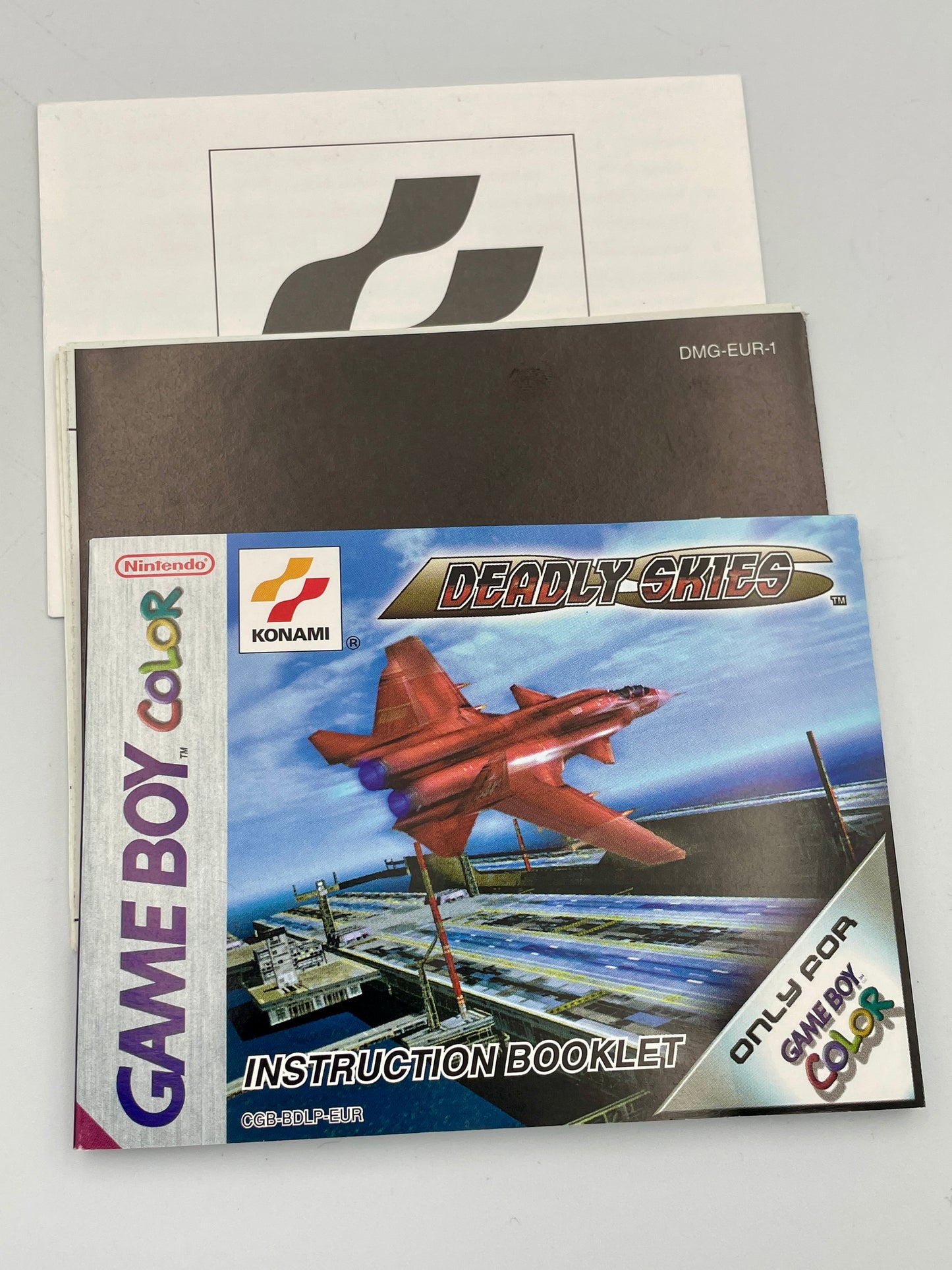 Game Boy Color 'Deadly Skies' instruction booklet with Konami logo on a gray background