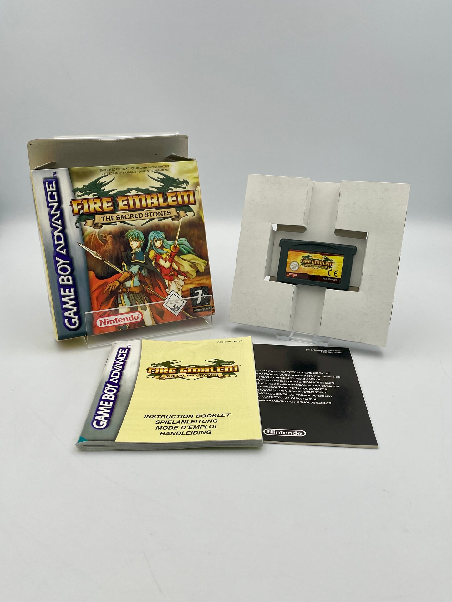 Nintendo Game Boy Advance game 'Fire Emblem: Shadows of Valentia' with packaging and manual on a gray background