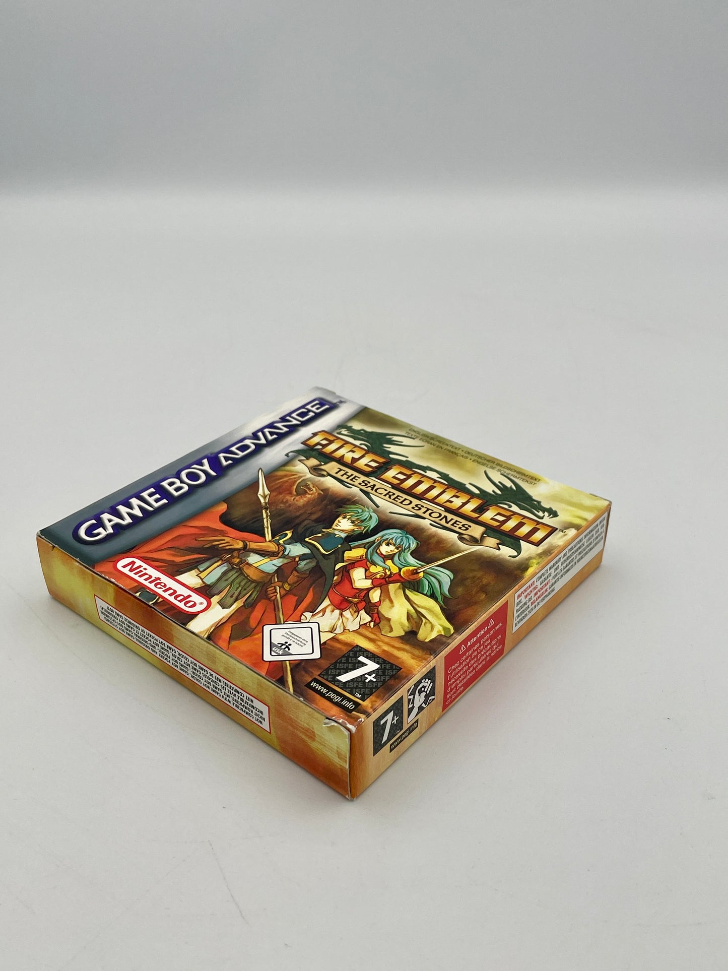 Game box for 'Fire Emblem: The Sacred Stones' on Game Boy Advance with characters and dragon illustration.