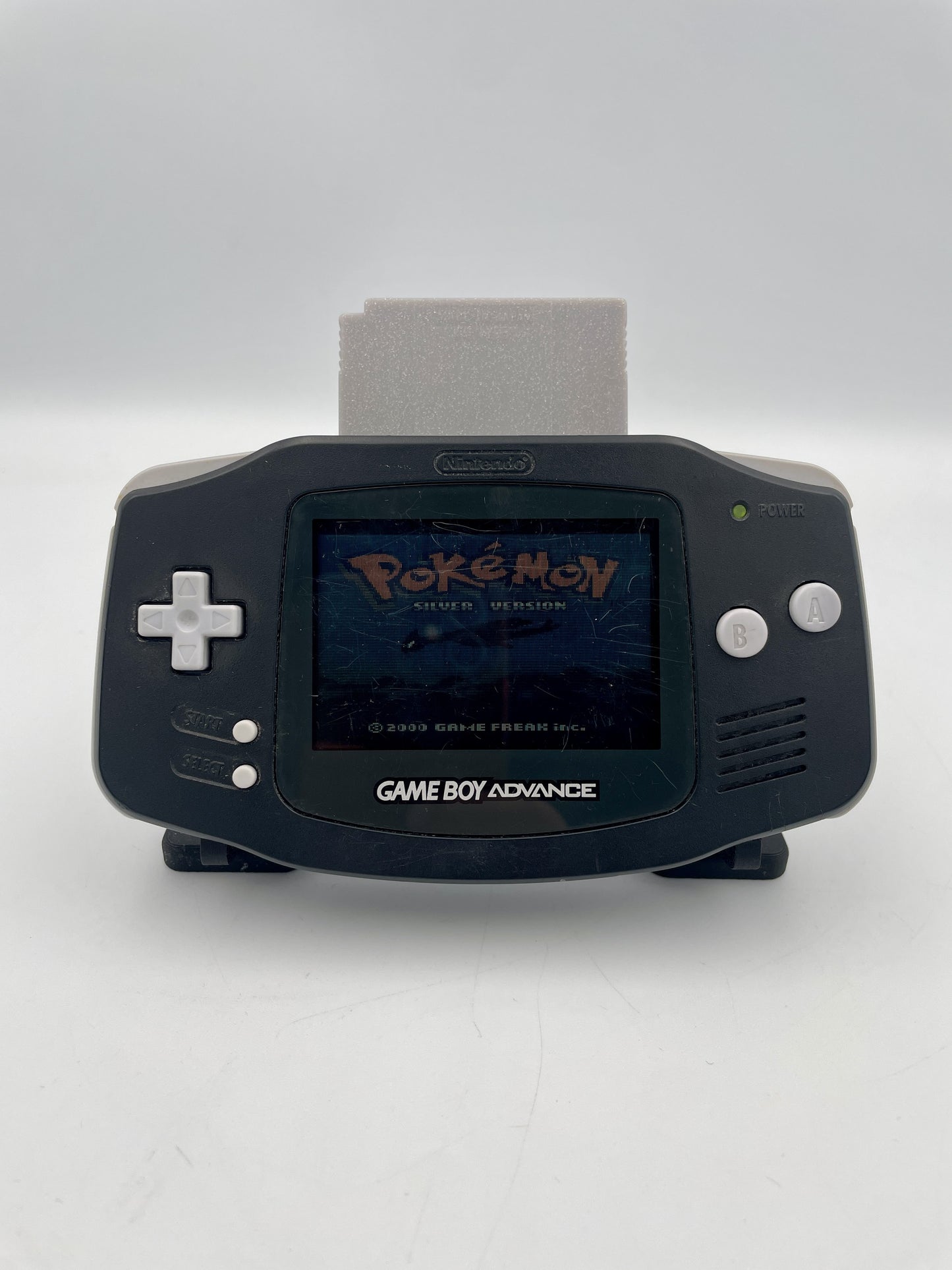 Black Game Boy Advance with a 'Pokémon' game displayed on the screen against a white background