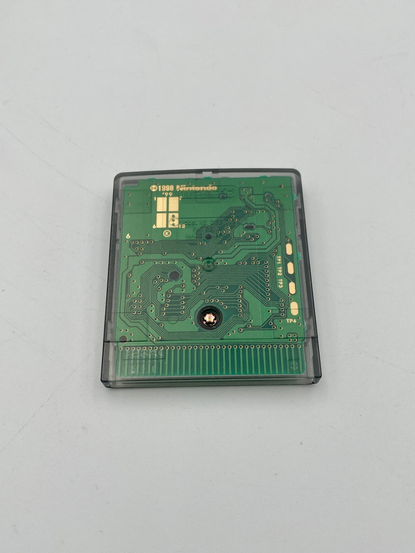 Green circuit board in a cartridge case on a light gray background