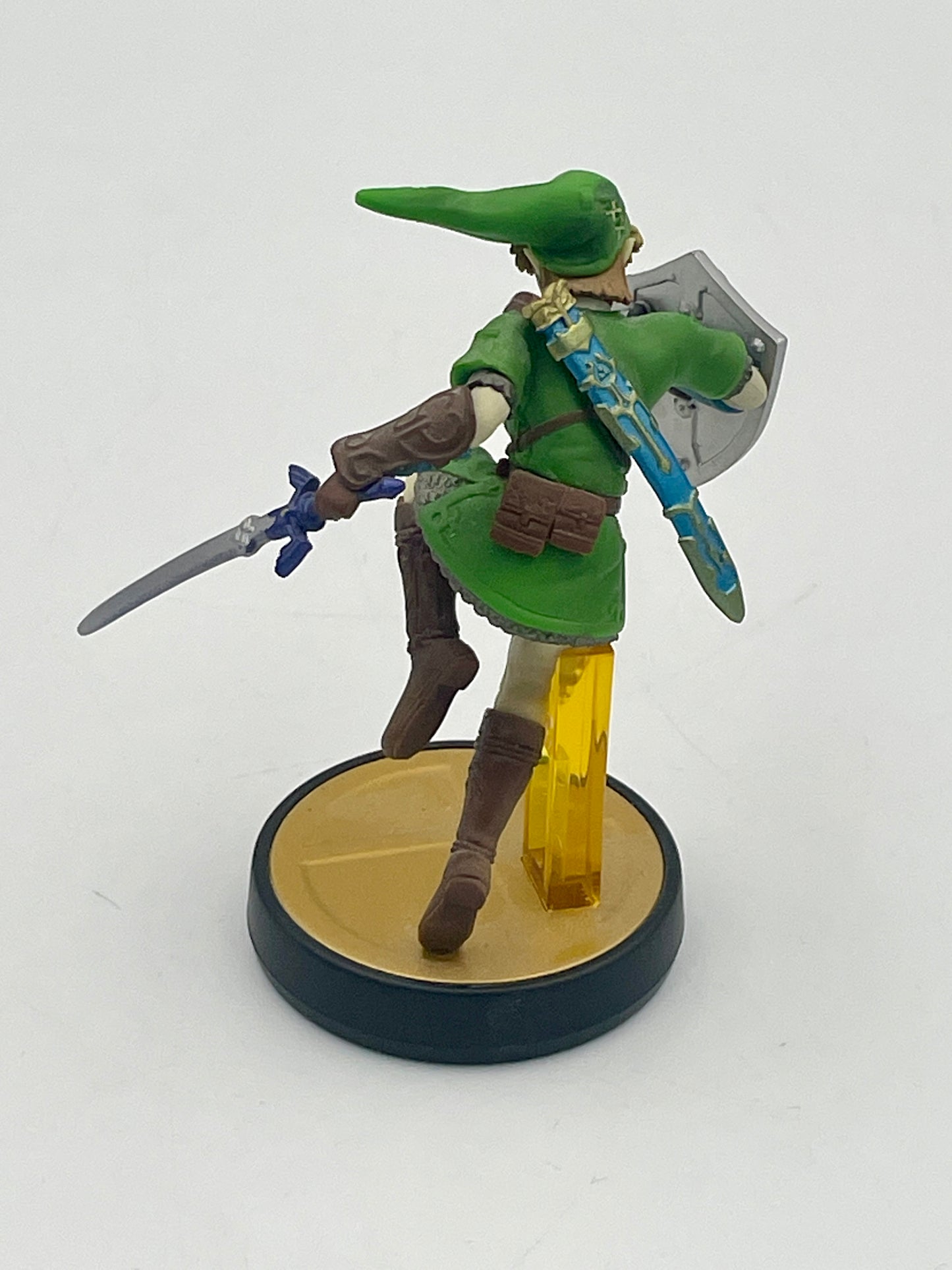 Figurine of a character in green outfit with sword and shield on a white background
