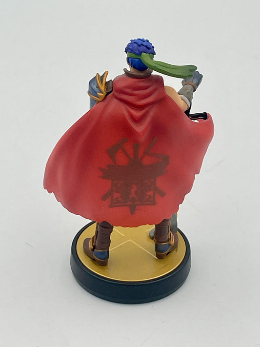 Figurine with a red cape and emblem on a white background