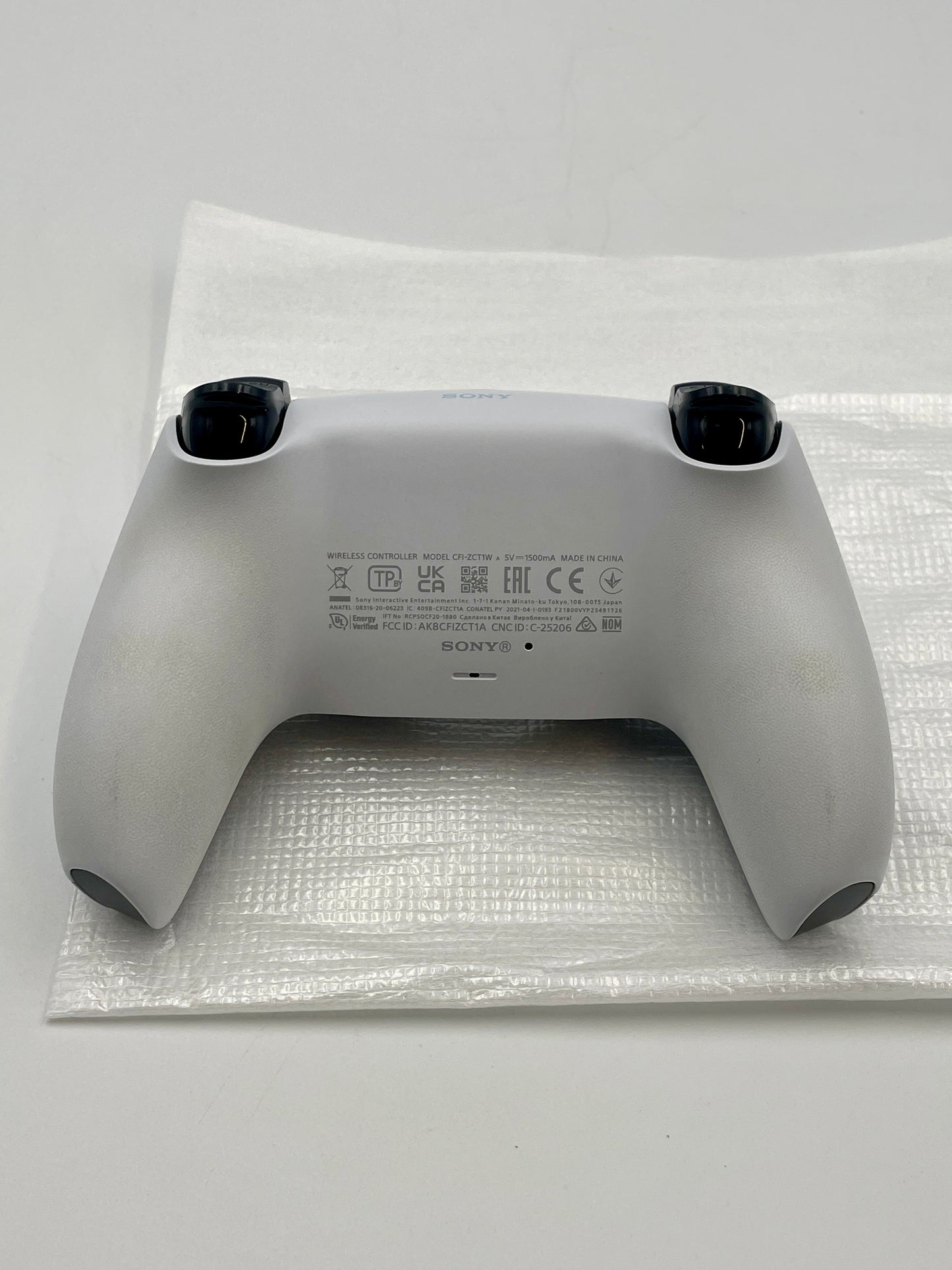 Gray PS5 Dual sense controller on bubble wrap with Sony branding