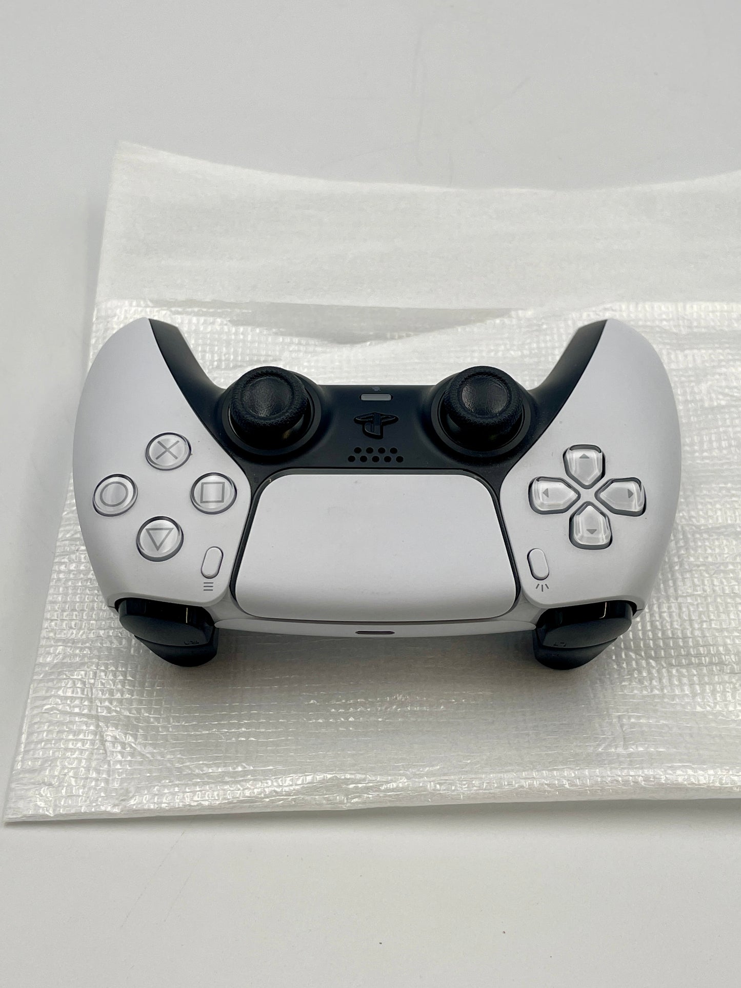PS5 Dual sense controller on a white surface with a clear protective cover.