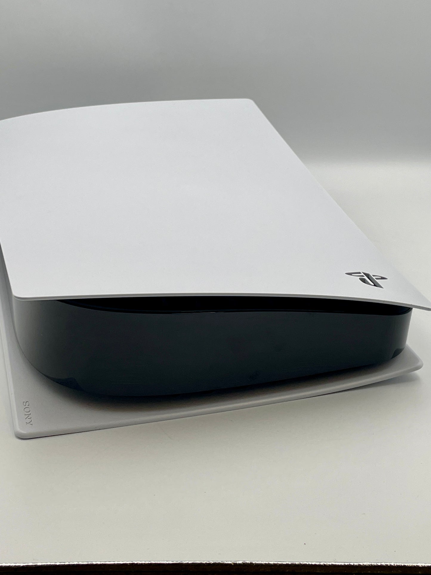 Black electronic device with a white cover on a gray surface