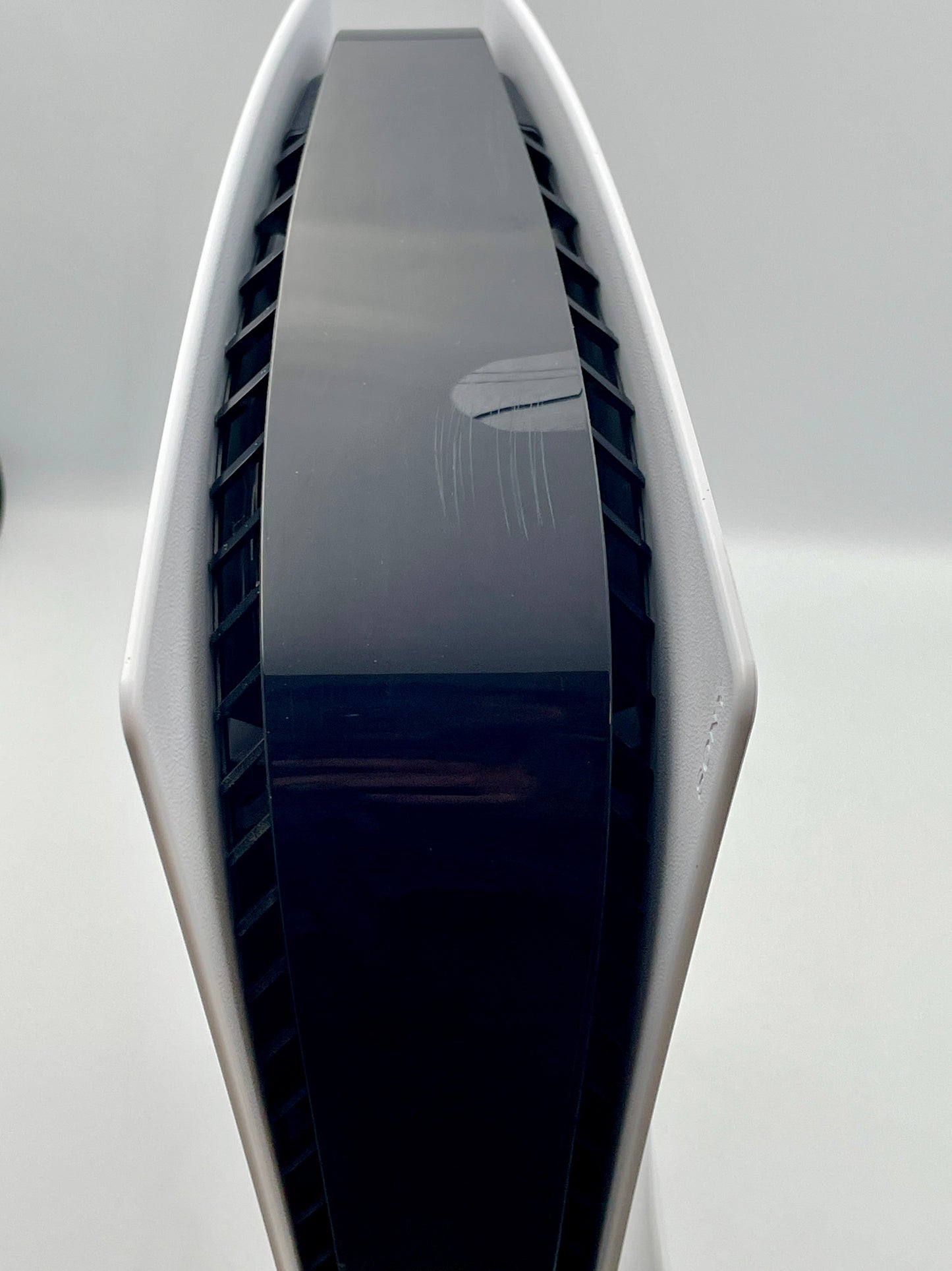 Modern, sleek electronic device with a reflective surface on a light gray background