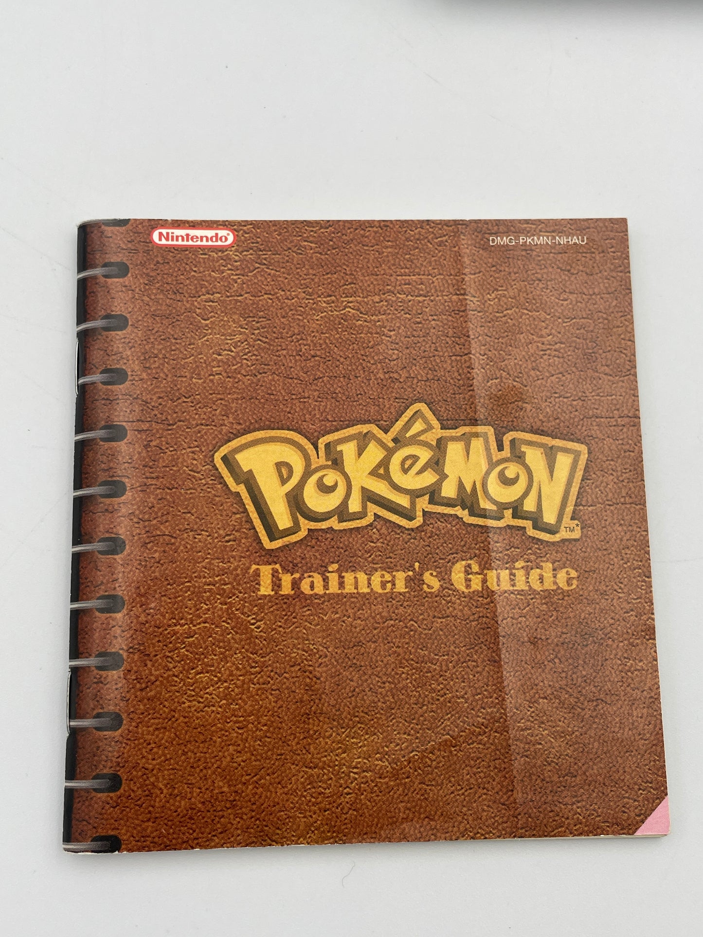 Brown notebook with 'Pokémon Trainer's Guide' text on a white background