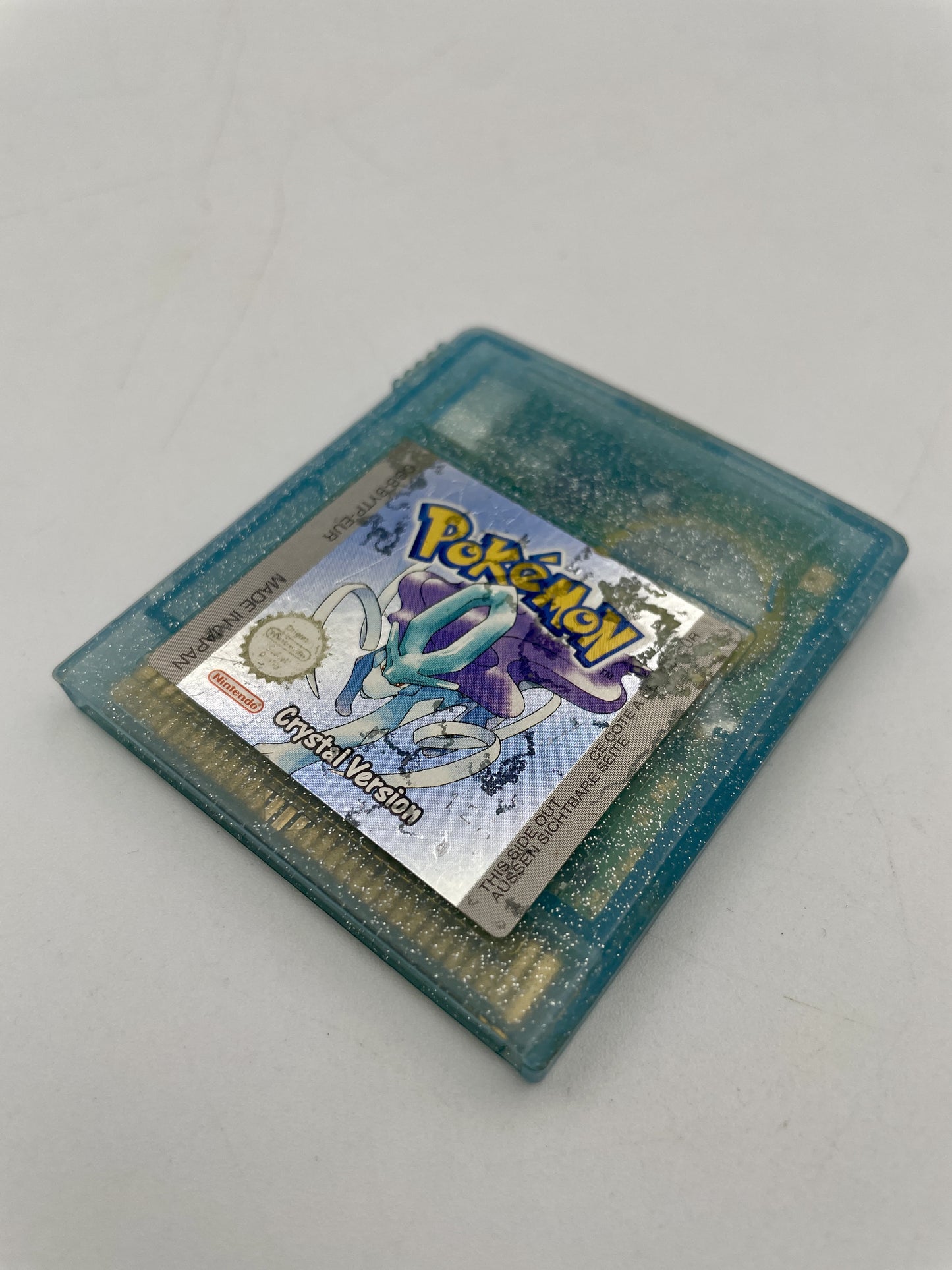 Vintage Pokémon Crystal Version game cartridge on a light gray background