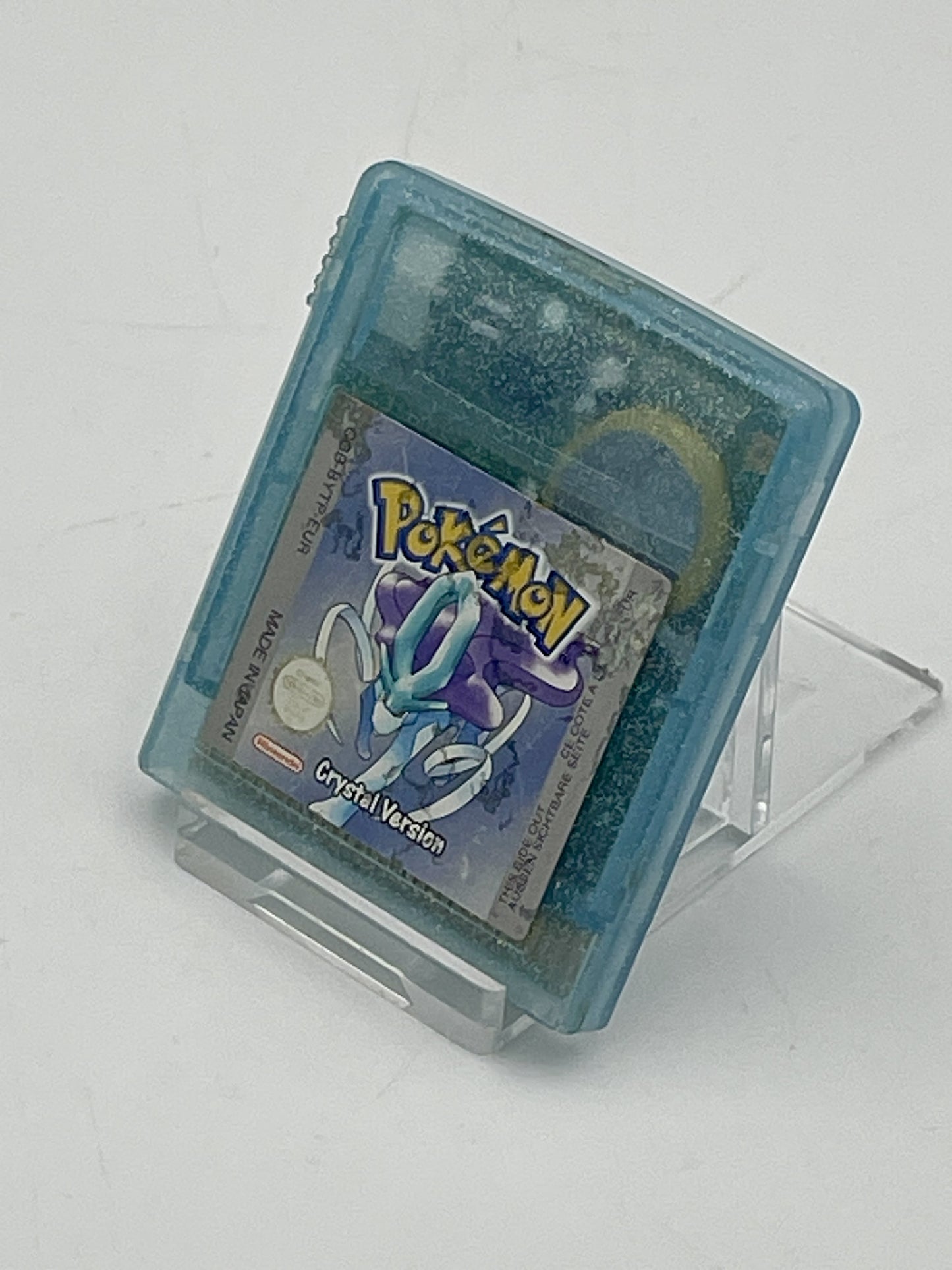 Pokémon Crystal Version game cartridge on a stand with a white background