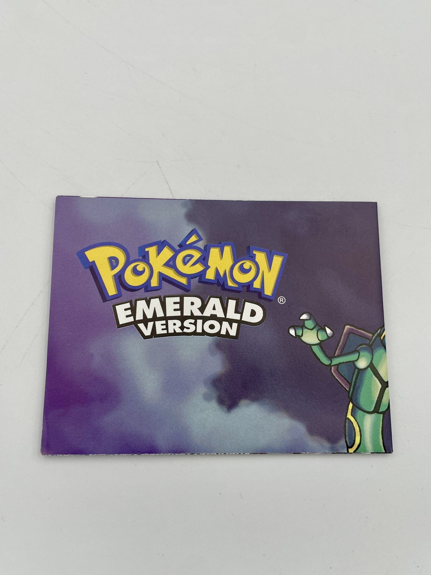 Pokémon Emerald Version game case on a gray background