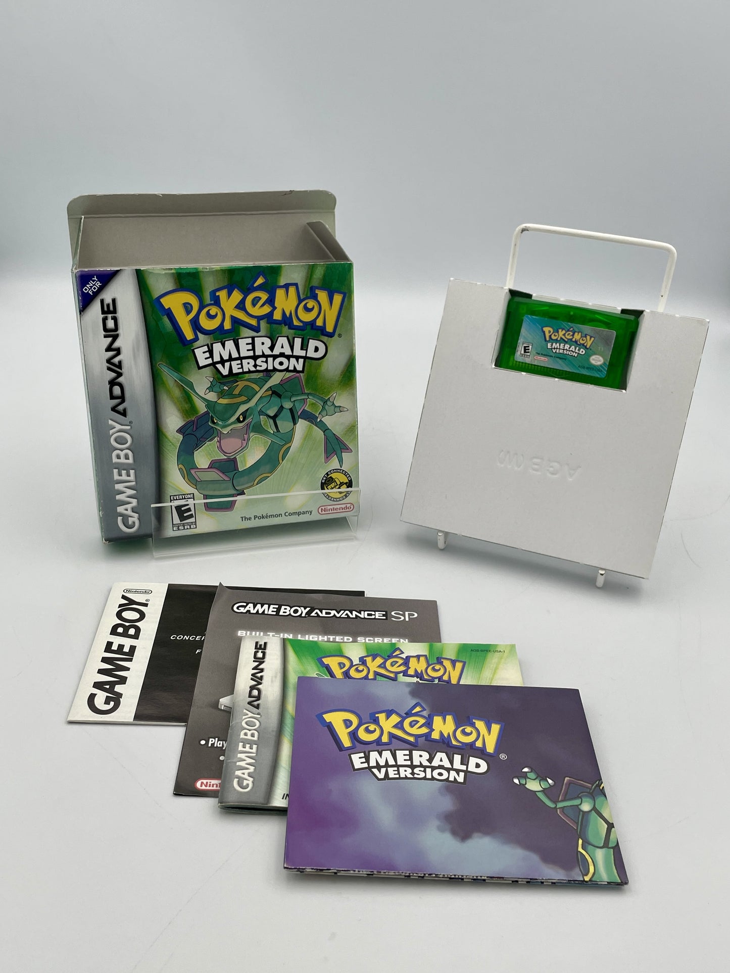 Pokémon Emerald Version Game Boy Advance game case with manuals on a white background