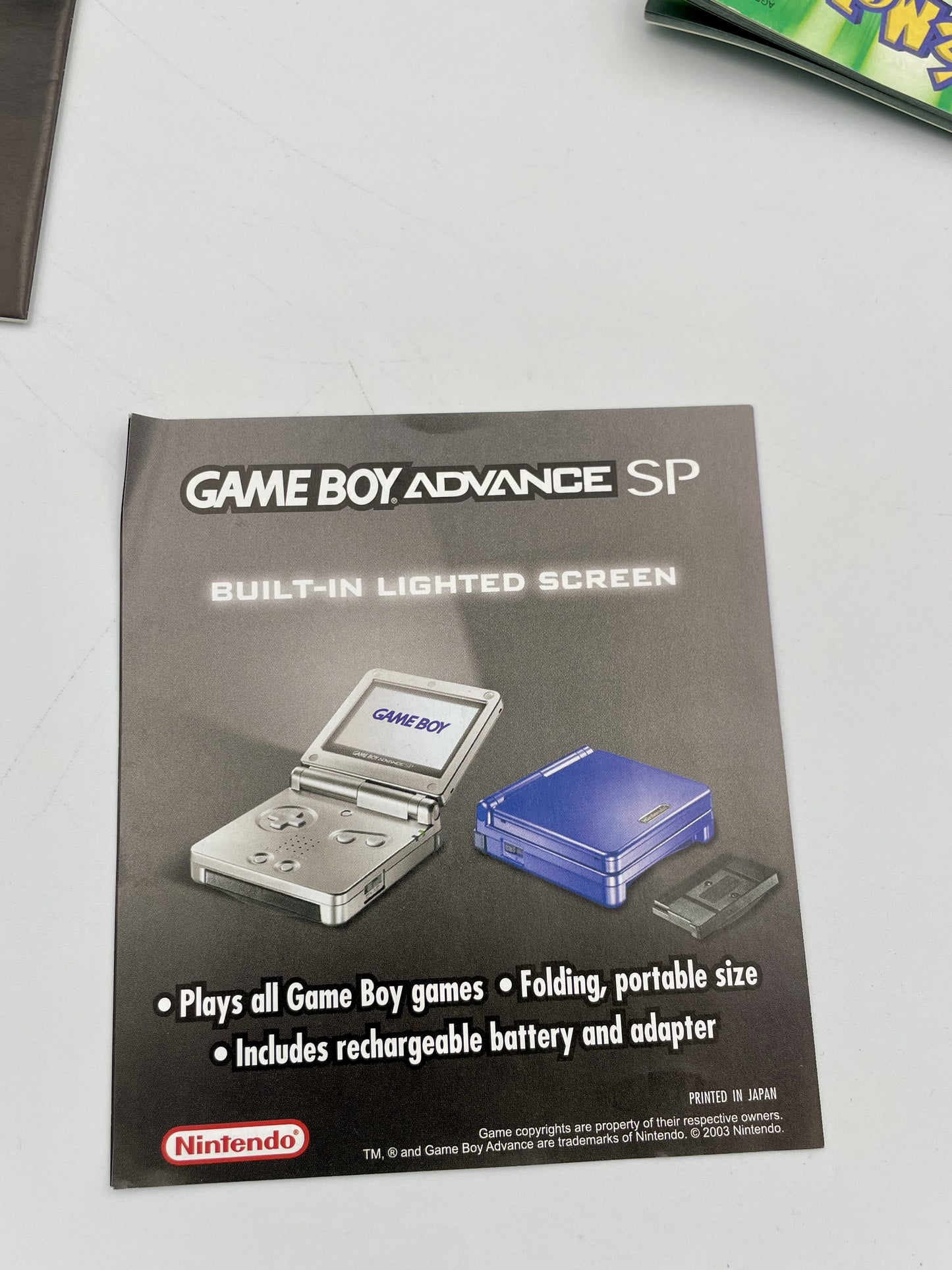 Advertisement for Game Boy Advance SP with images of the console on a gray background