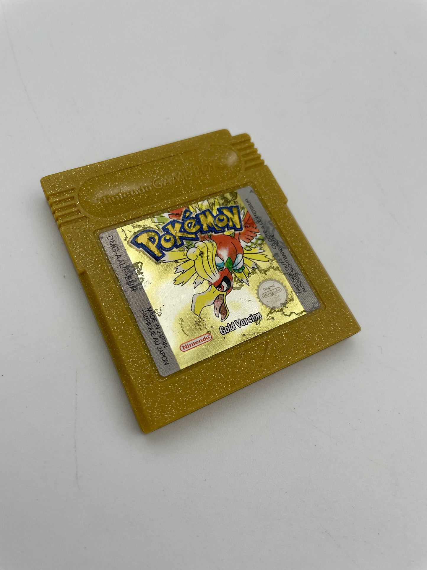 Gold-colored Game Boy cartridge with a Pokémon logo on a white background