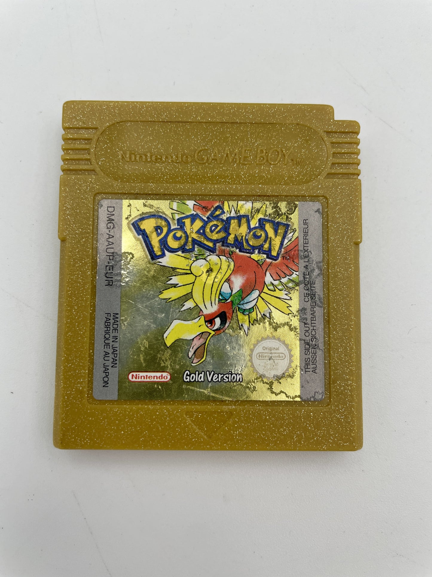 Gold Game Boy cartridge of 'Pokémon Gold Version' on a white background