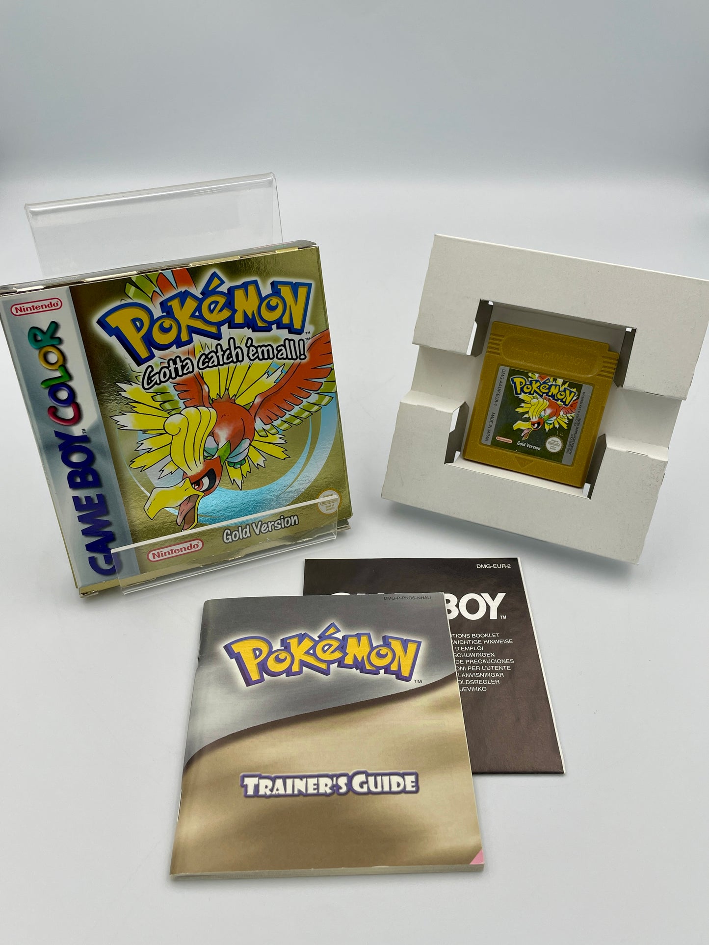 Pokémon Game Boy Color game cartridge with cover and trainer's guide on a white background