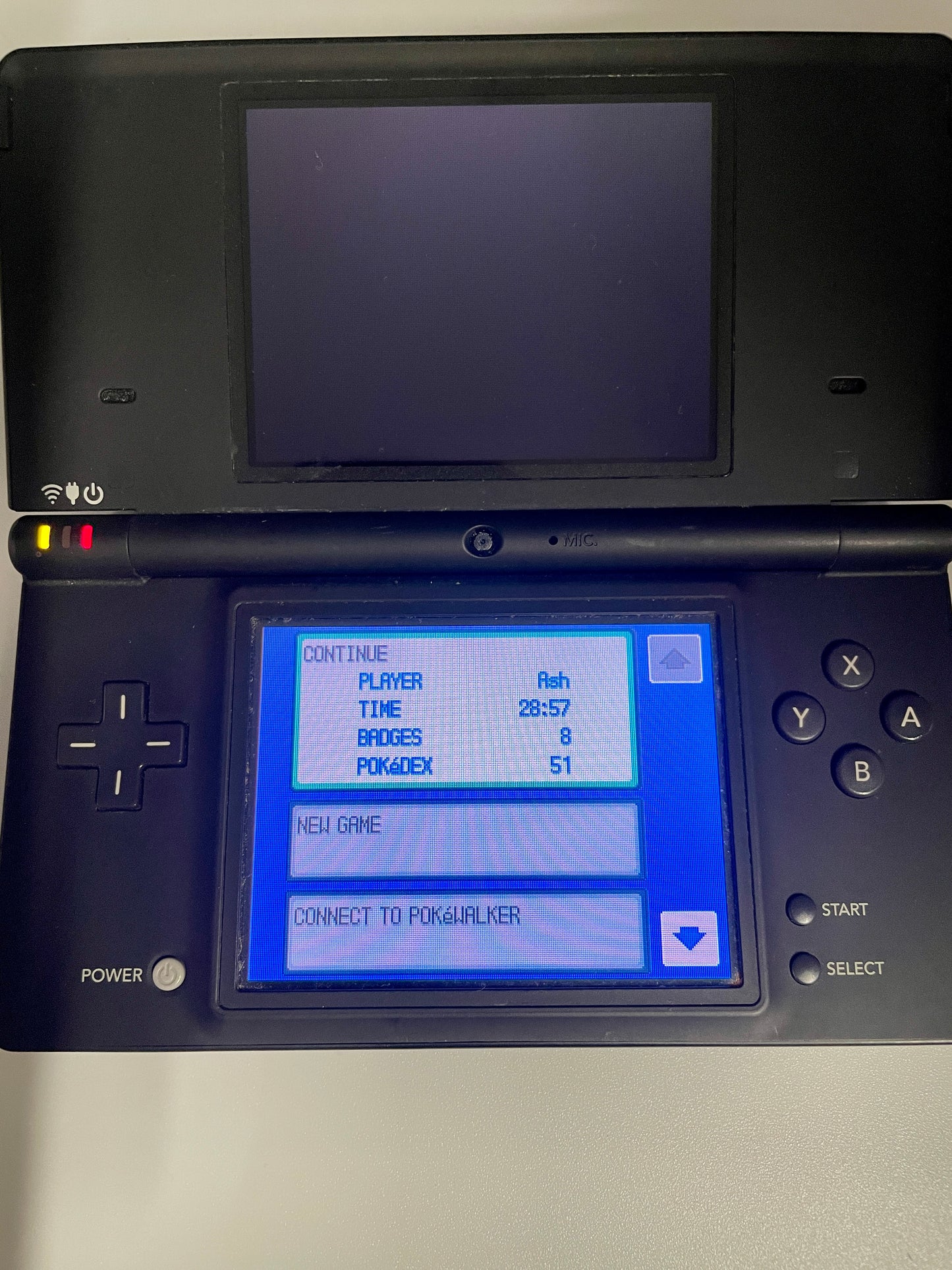 Black handheld gaming console with a blue screen displaying game interface