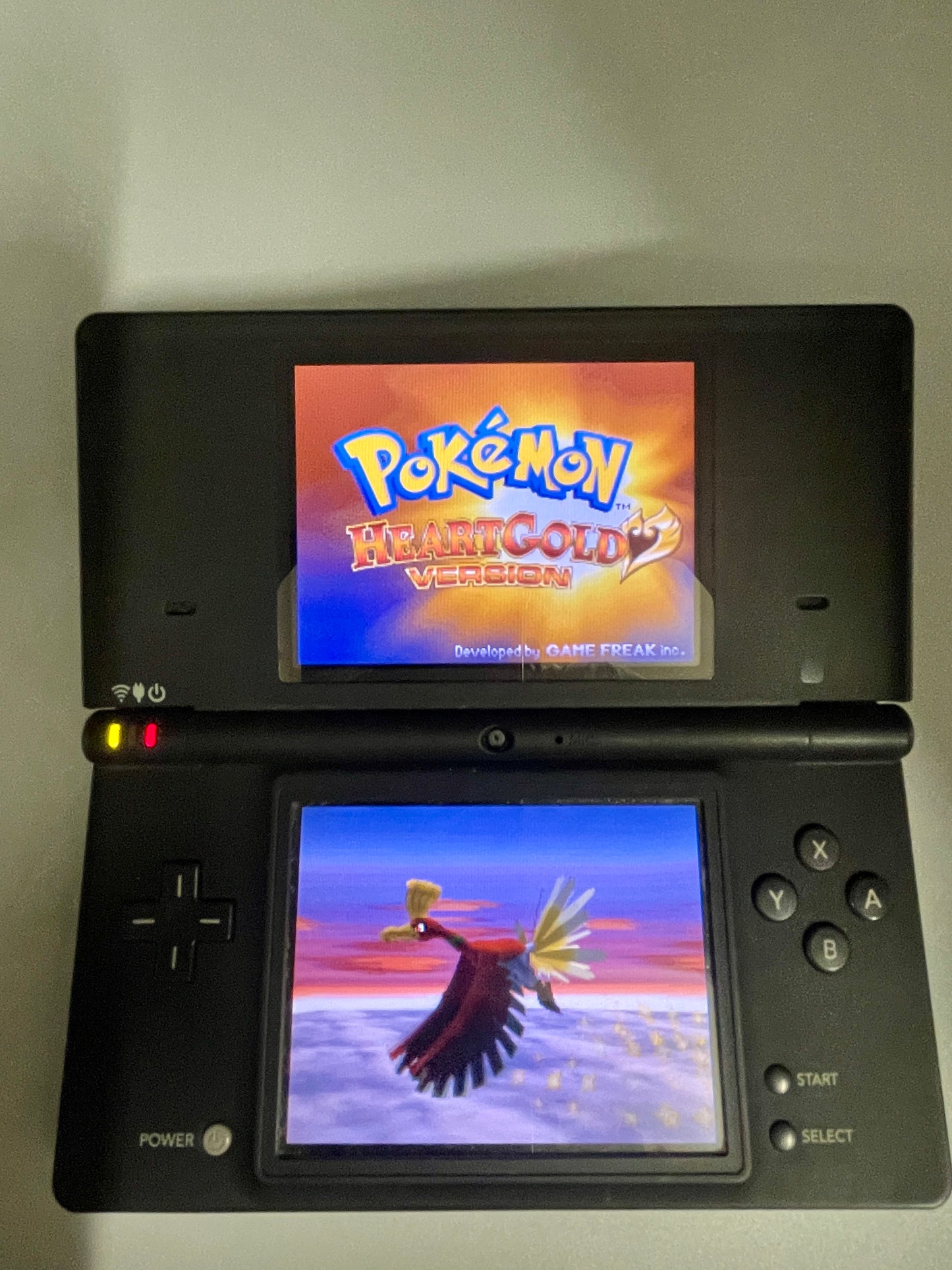 Nintendo DS gaming console displaying 'Pokémon heart gold' on the top screen and 'Pokémon Ho-Oh' on the bottom screen.