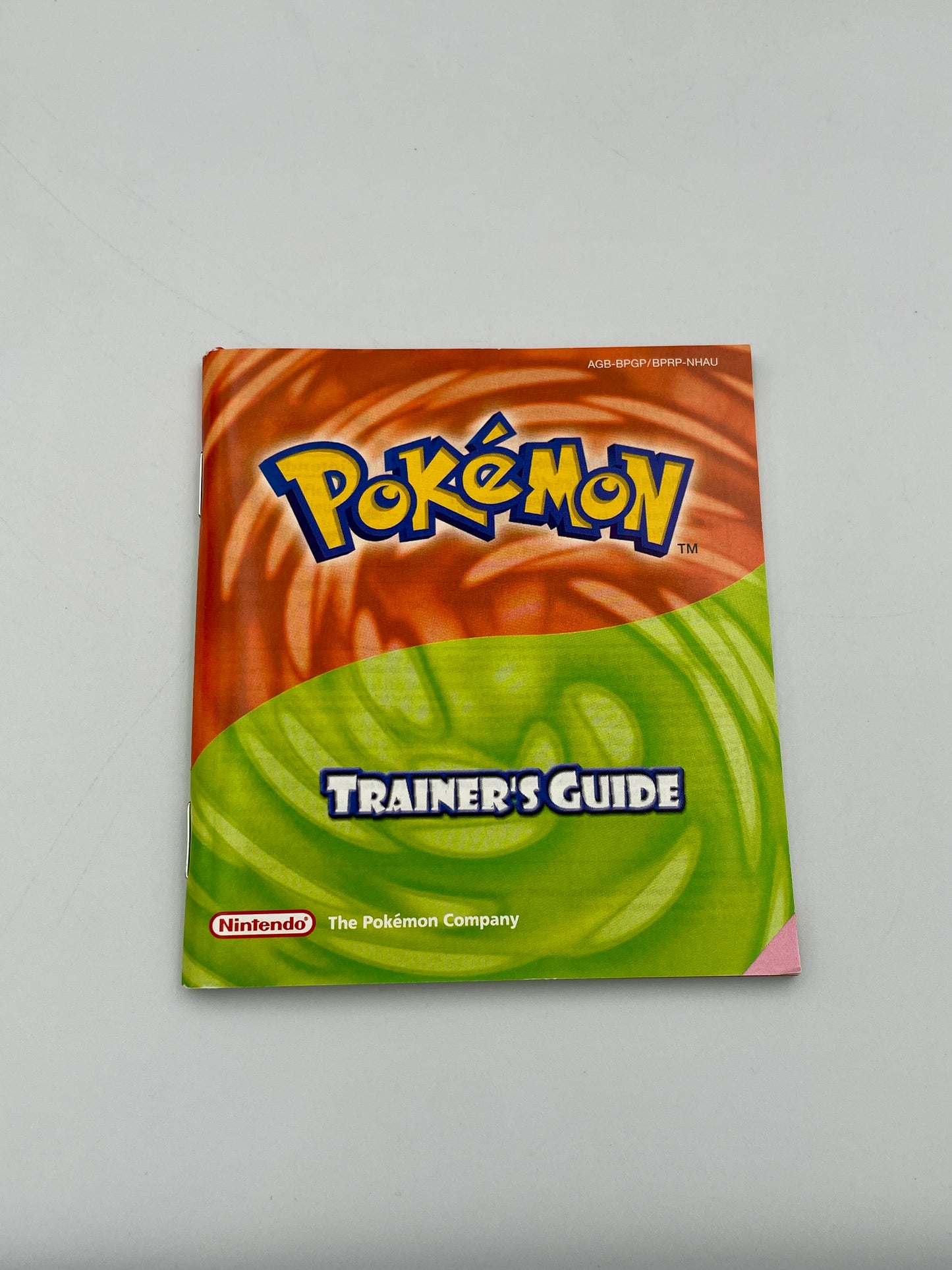 Pokémon Trainer's Guide book with colorful cover on a gray background
