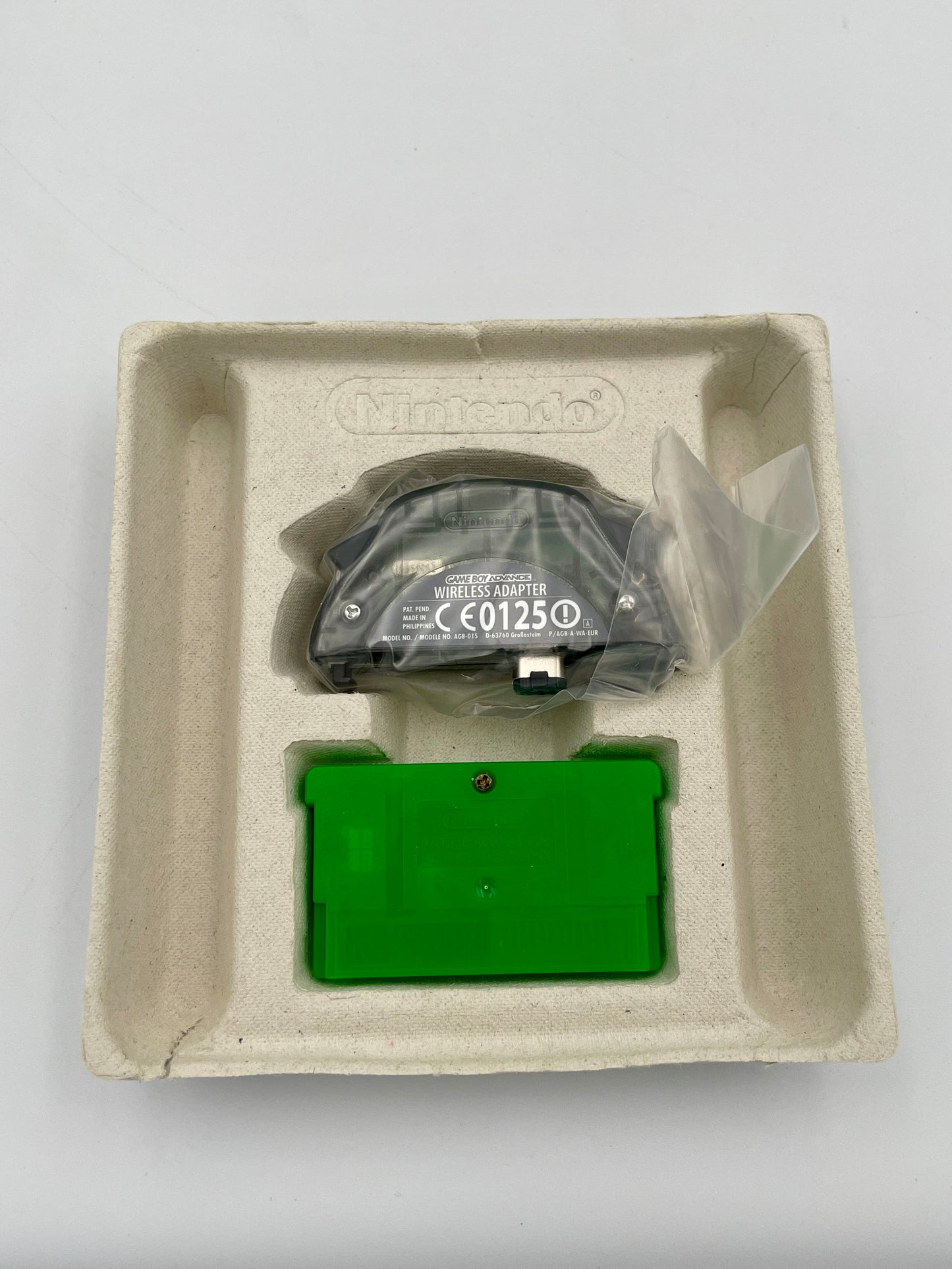 Green electronic device in a cardboard box on a gray background