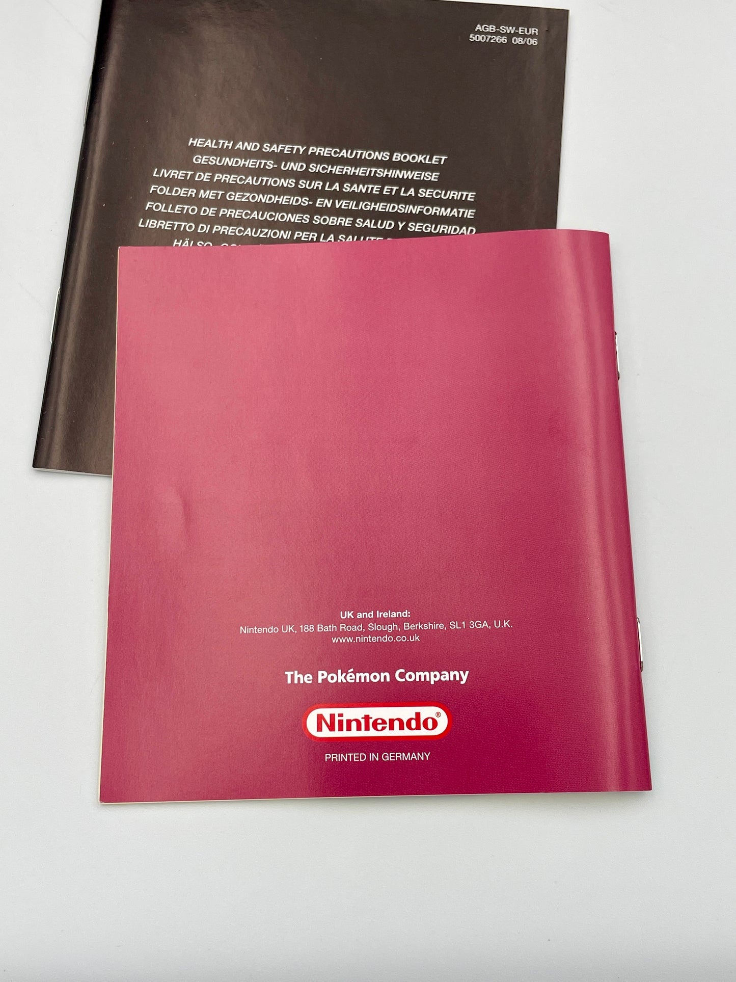 Two books, one brown and one red with Nintendo logo, on a light gray background