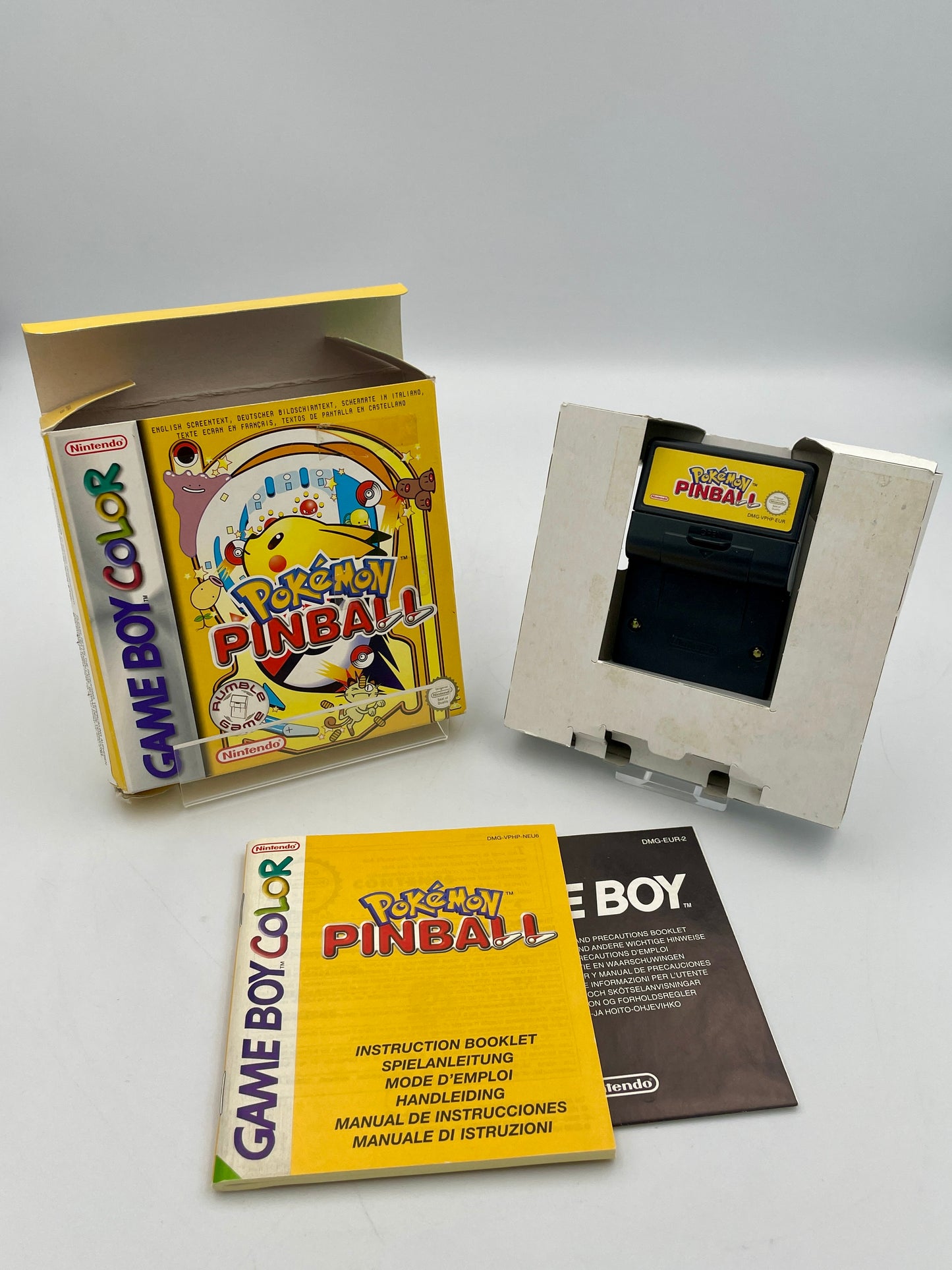 Game Boy Color with 'Pokémon Pinball' cartridge and packaging on a white background