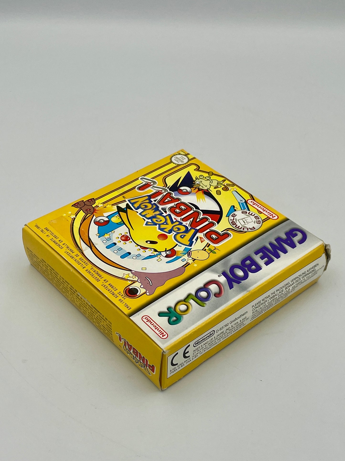 Yellow Game Boy Color packaging with colorful graphics on a white background