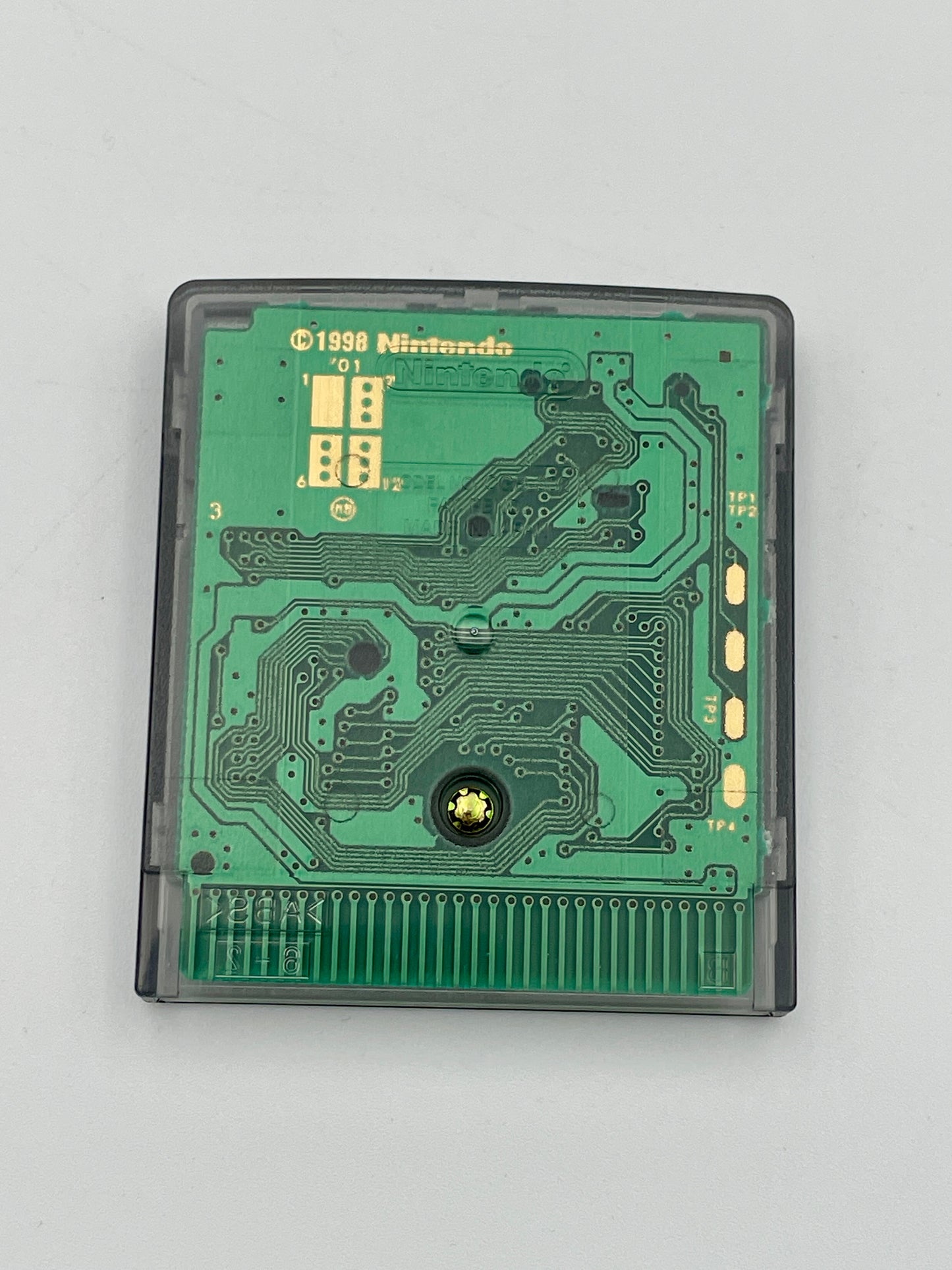 Nintendo game cartridge with green circuit board on a gray background