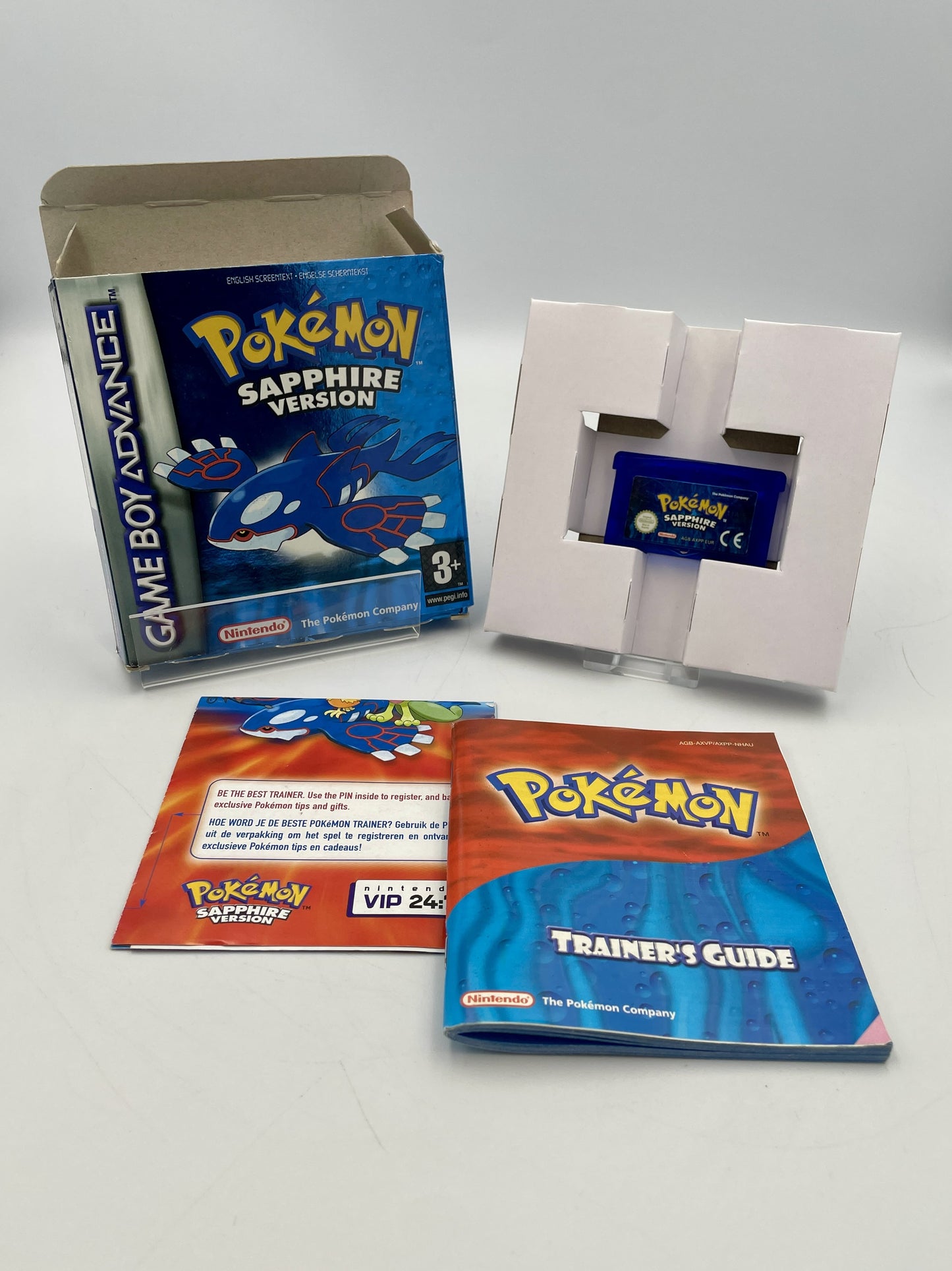 Pokémon Sapphire Version Game Boy Advance game cartridge with packaging and accessories on a white background