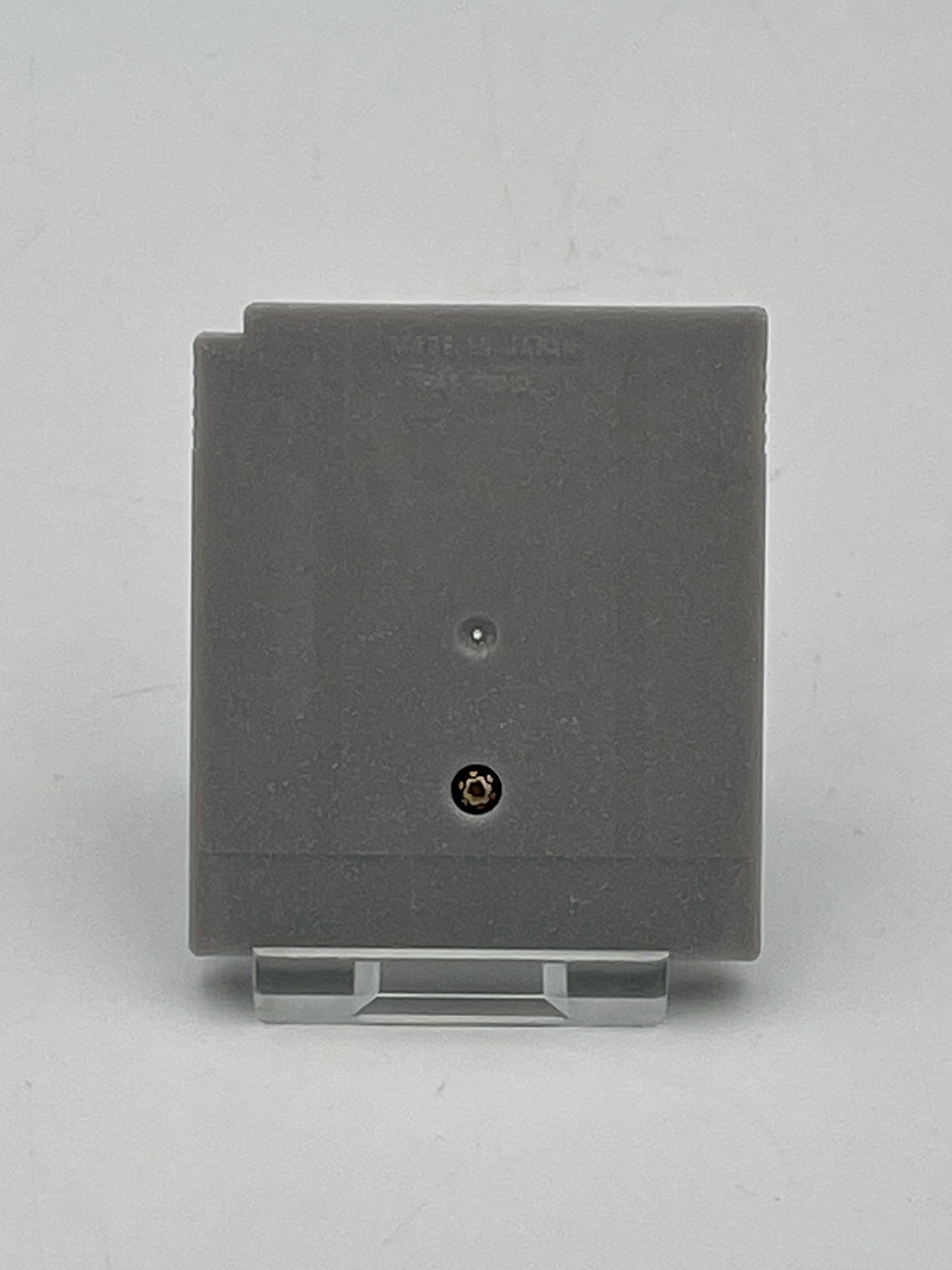Gray square wall plate with a screw on a light gray background