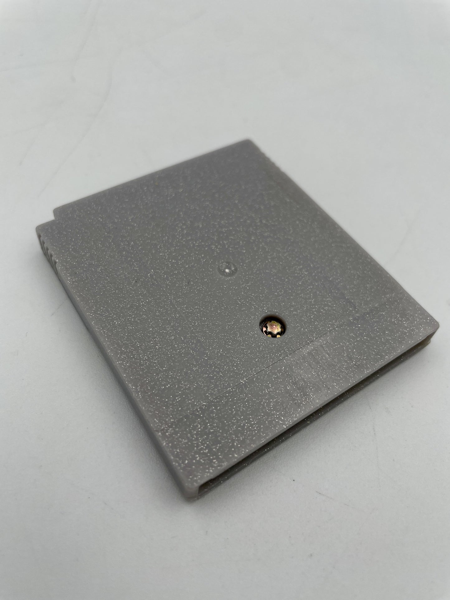 Gray textured wallet with a gold button on a light gray background