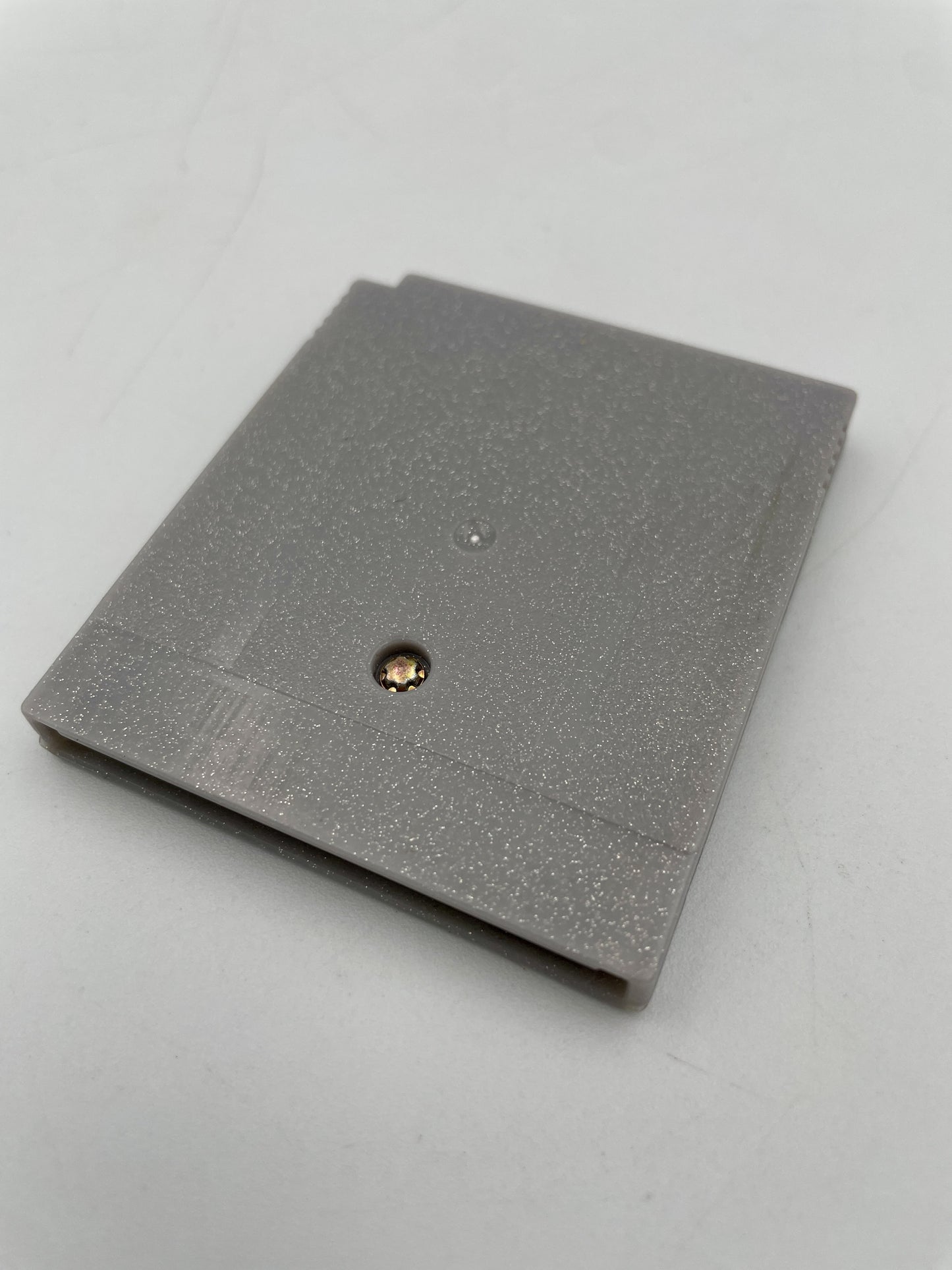 Gray textured notebook with a gold and black button on a light gray background