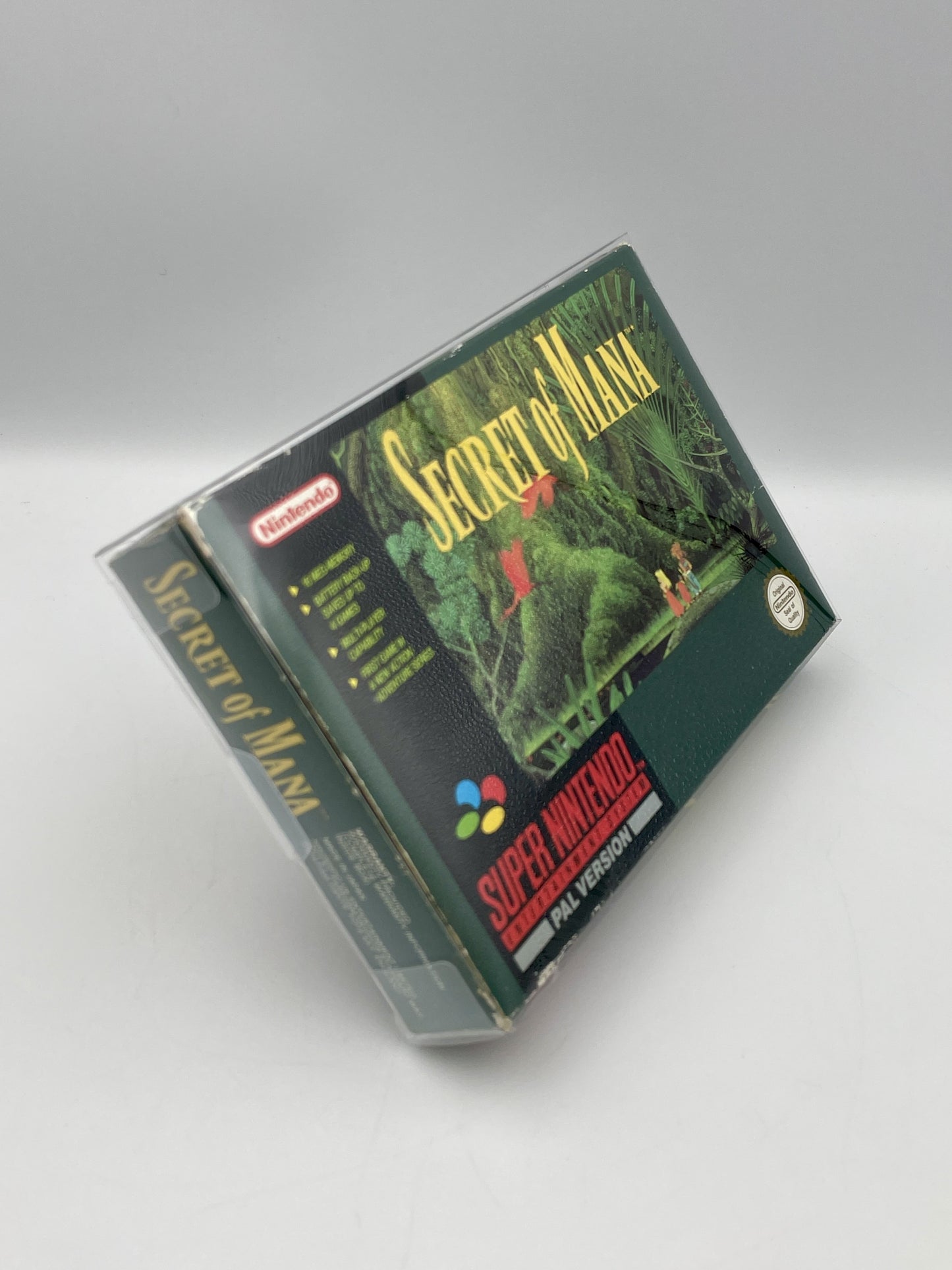 Super Nintendo Entertainment System game cartridge for 'Secret of Mana' on a gray background