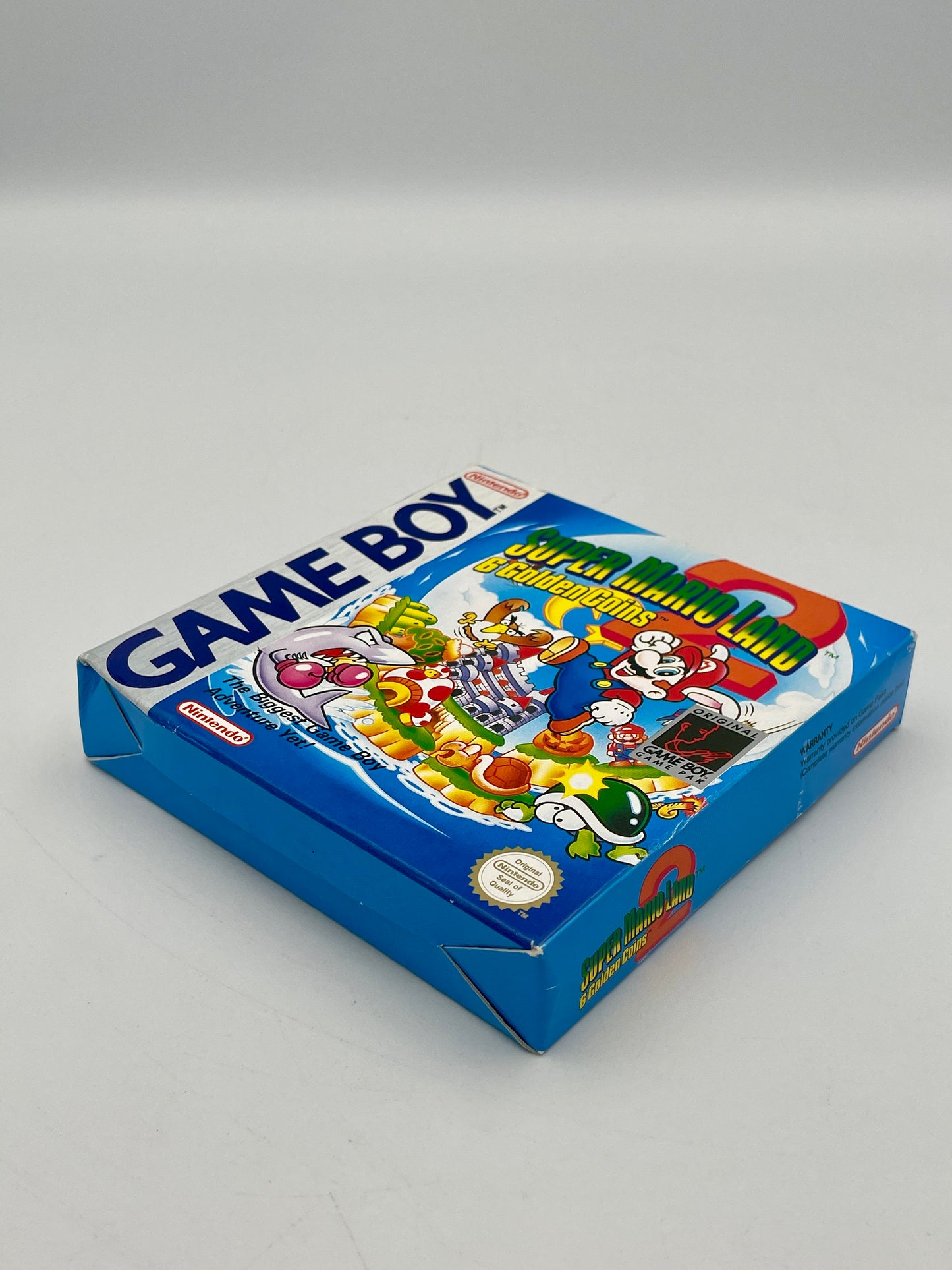 Vintage Game Boy packaging with colorful graphics on a gray background