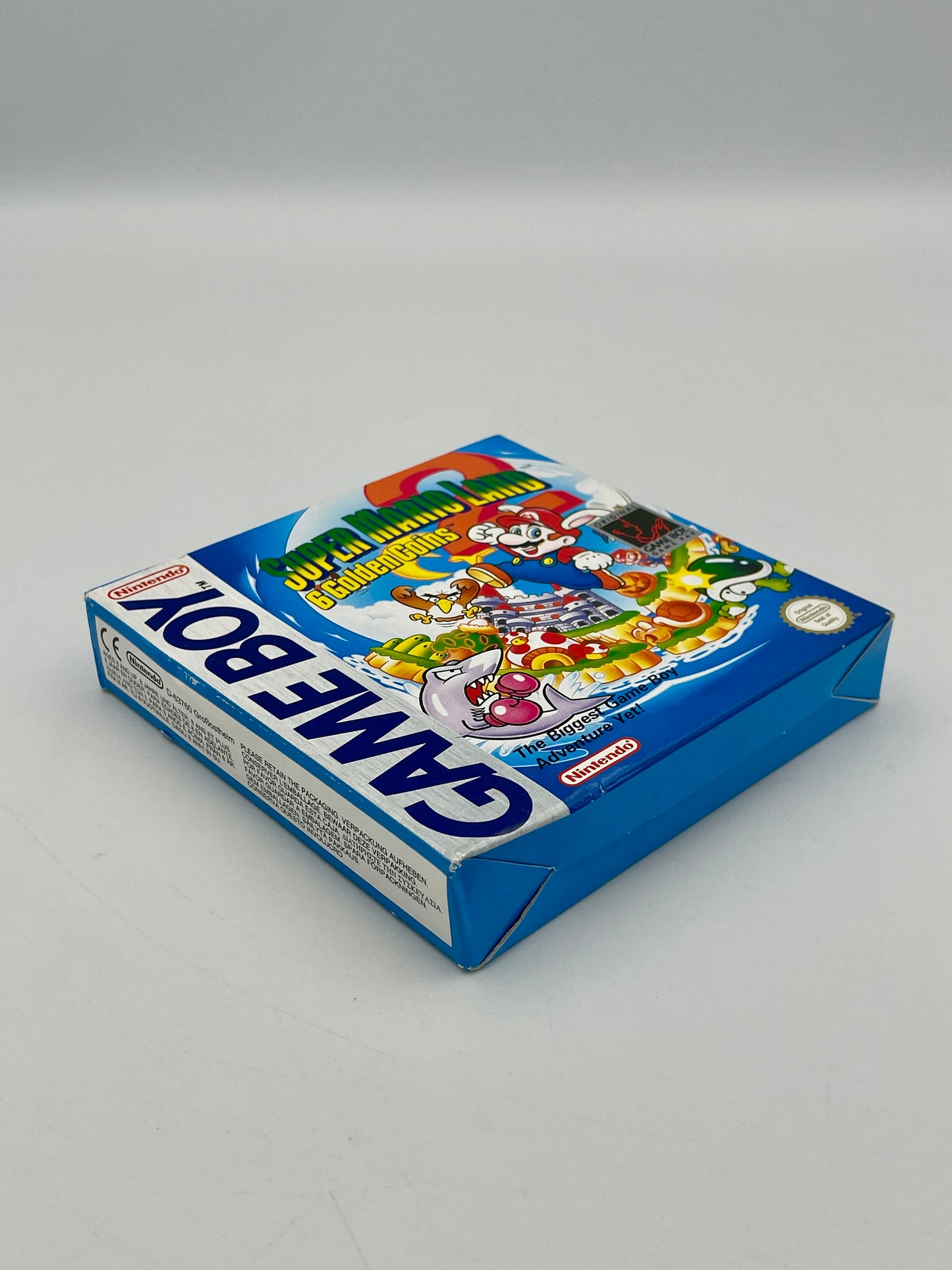 Blue Game Boy packaging with colorful graphics on a gray background