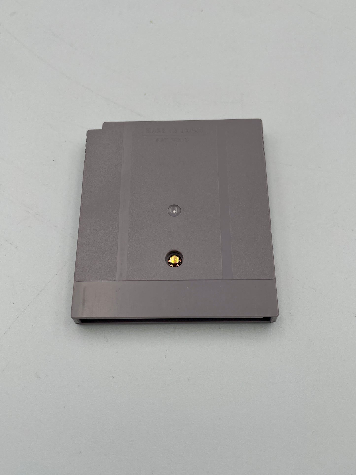 Gray rectangular object with a small round component on a light gray background