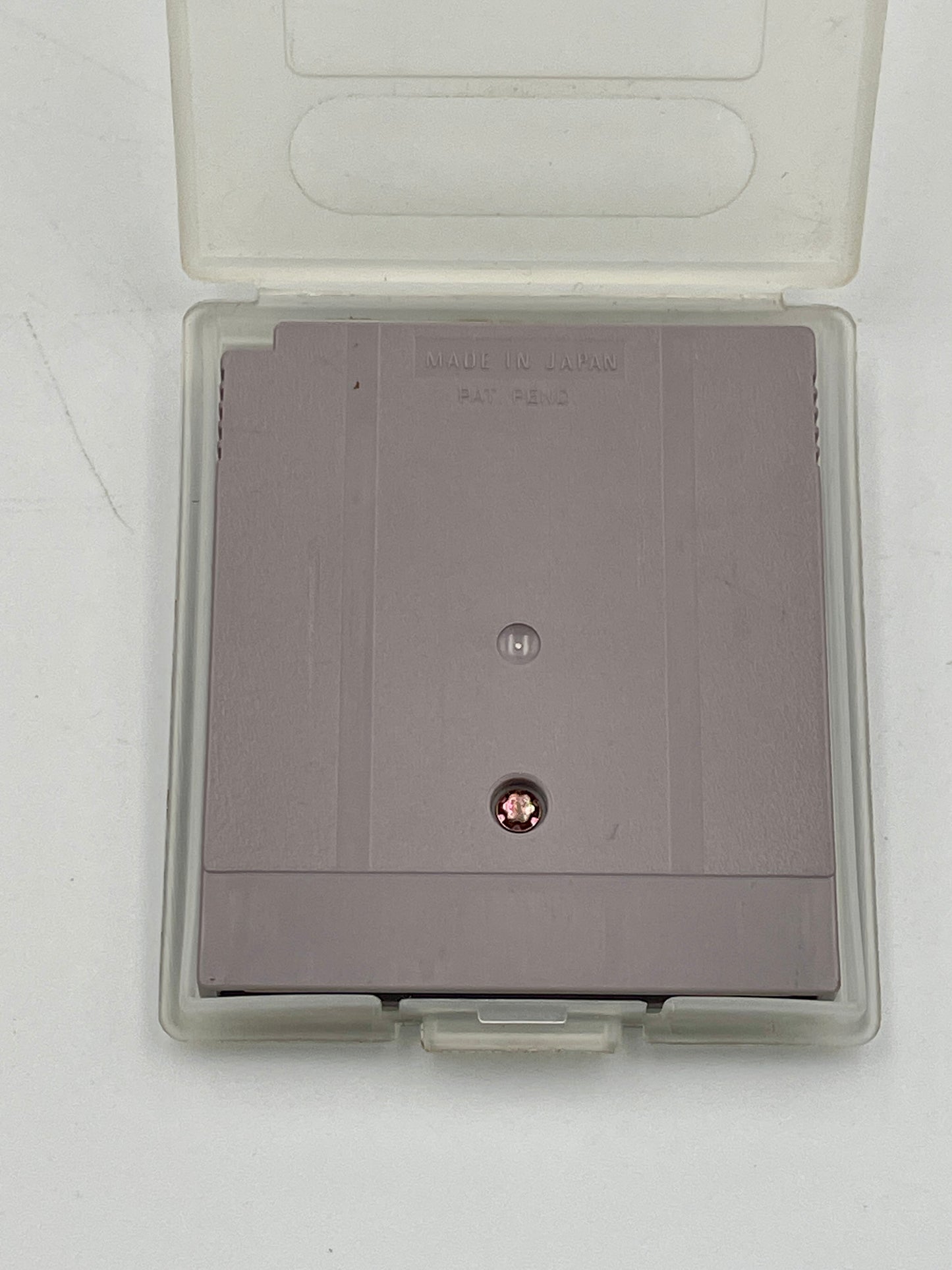 Gray game cartridge in a transparent case on a white background