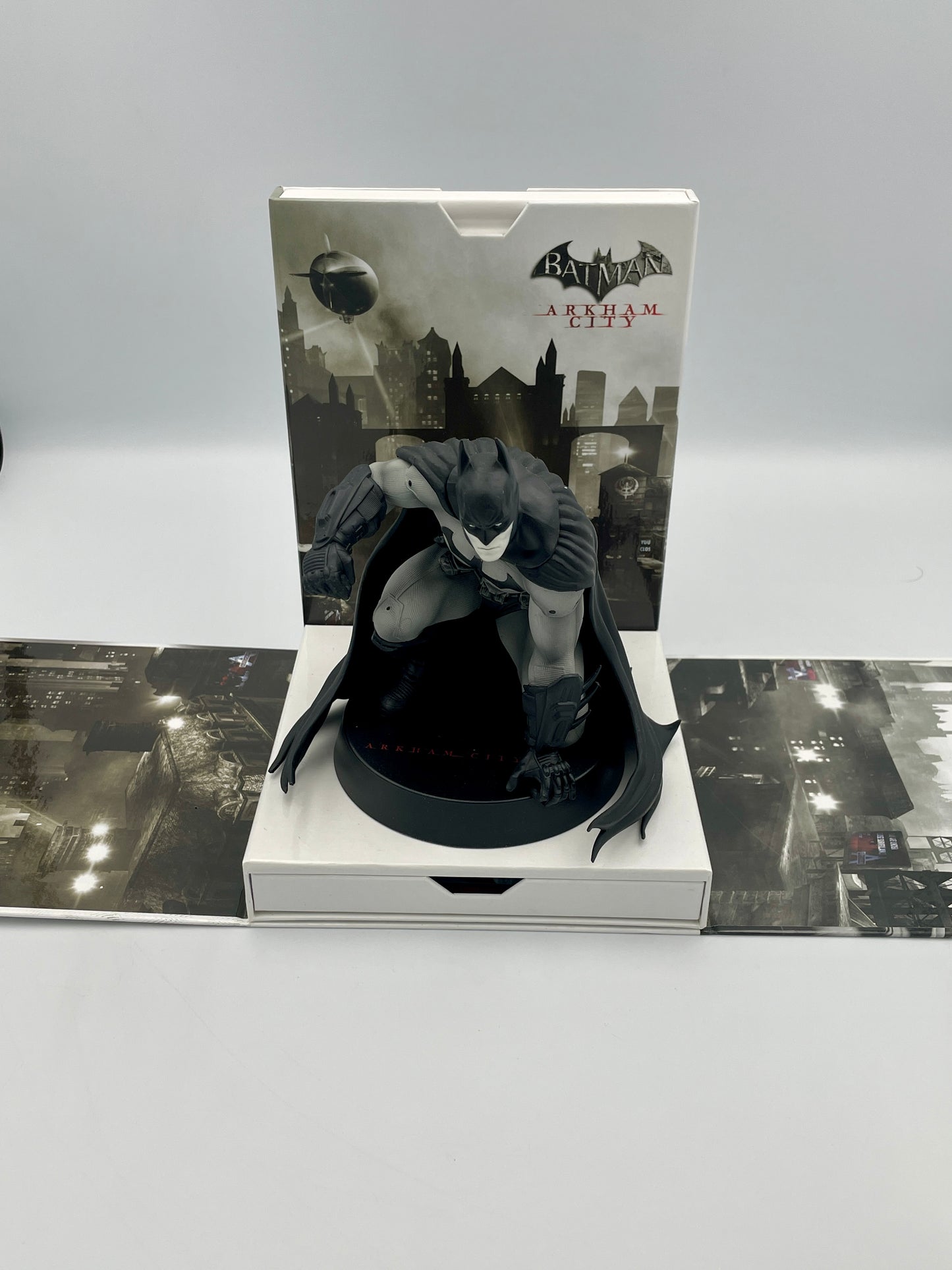 Batman Arkham City figurine in packaging with cityscape design