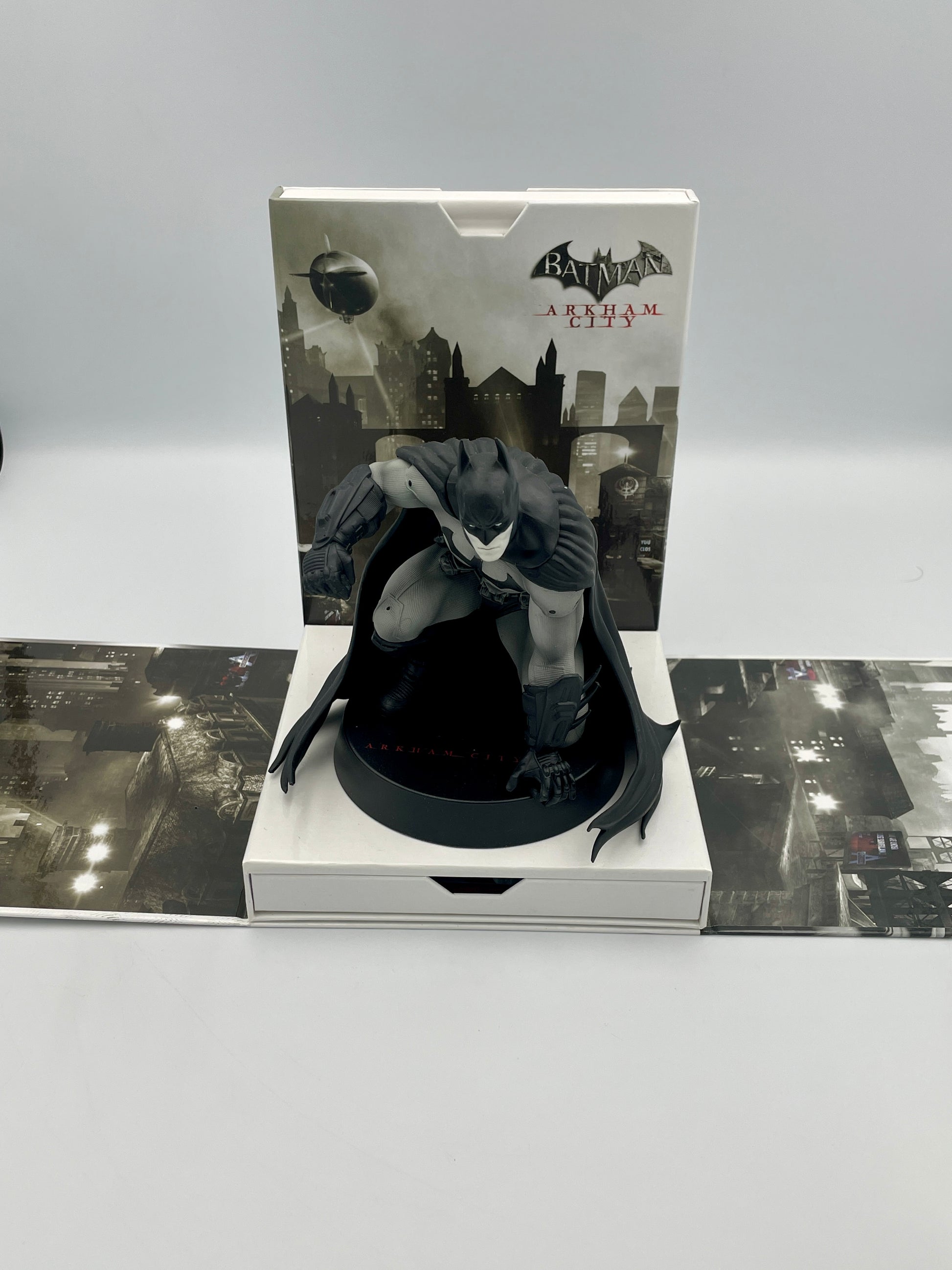 Batman Arkham City figurine in packaging with cityscape design