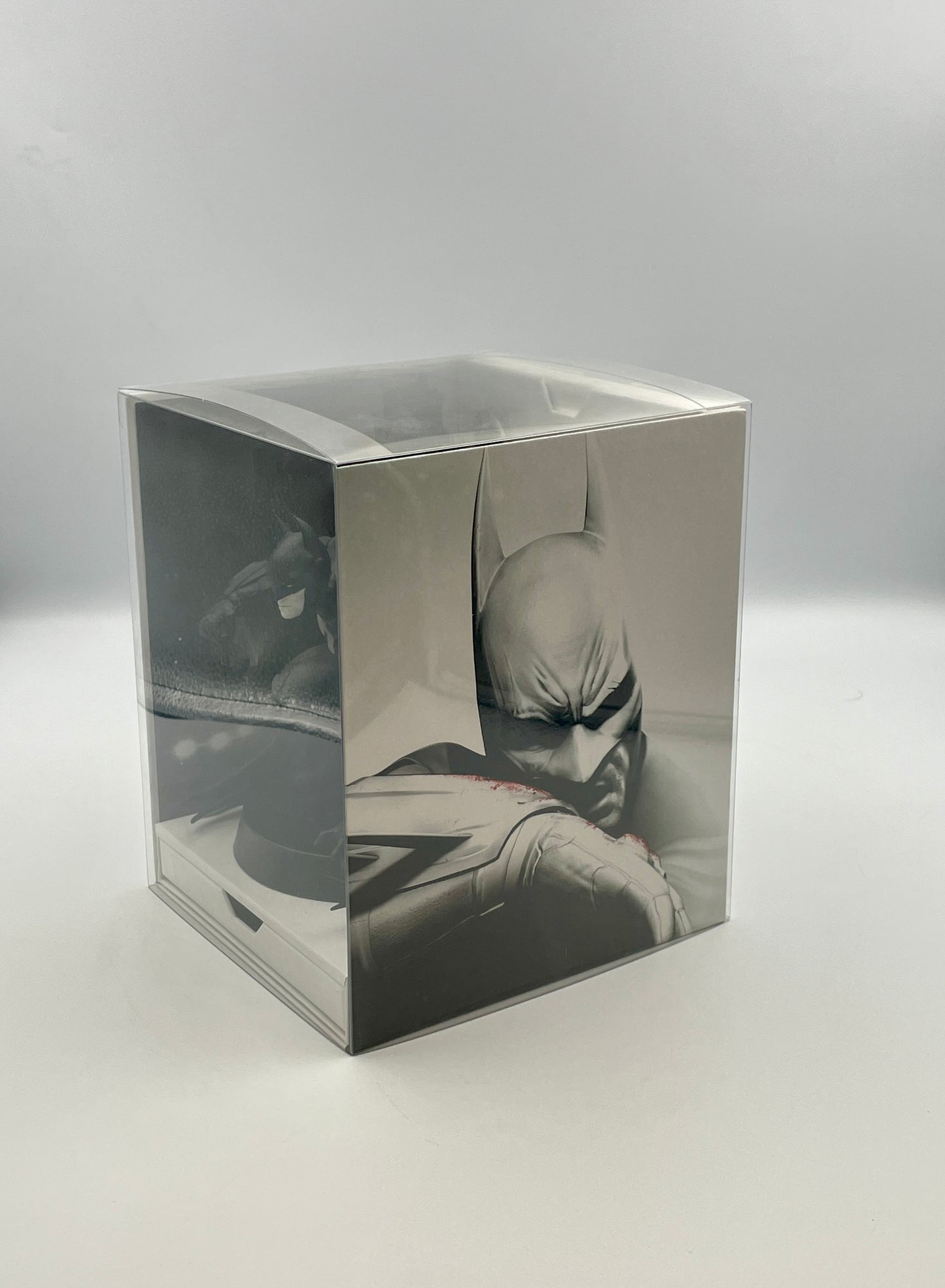 Silver cube with reflective surface showing a black and white image of a person lying down.