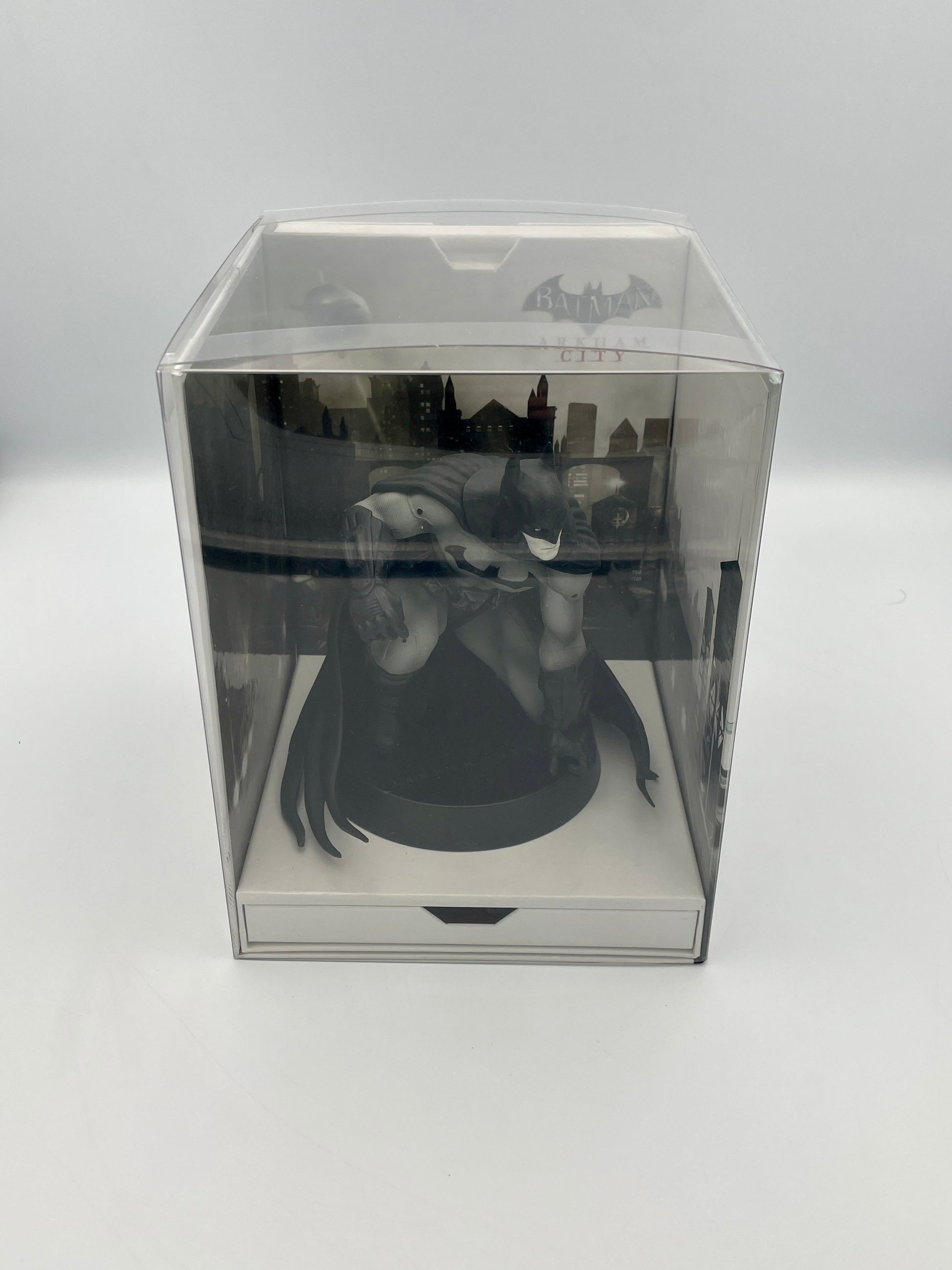 Statue of batman in a clear box on a white background