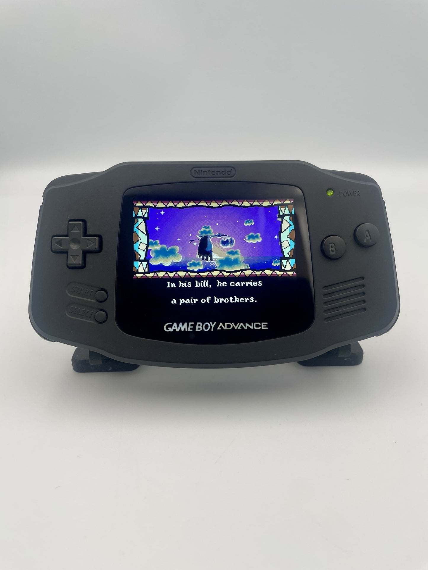 Black Game Boy Advance displaying a game on a white background
