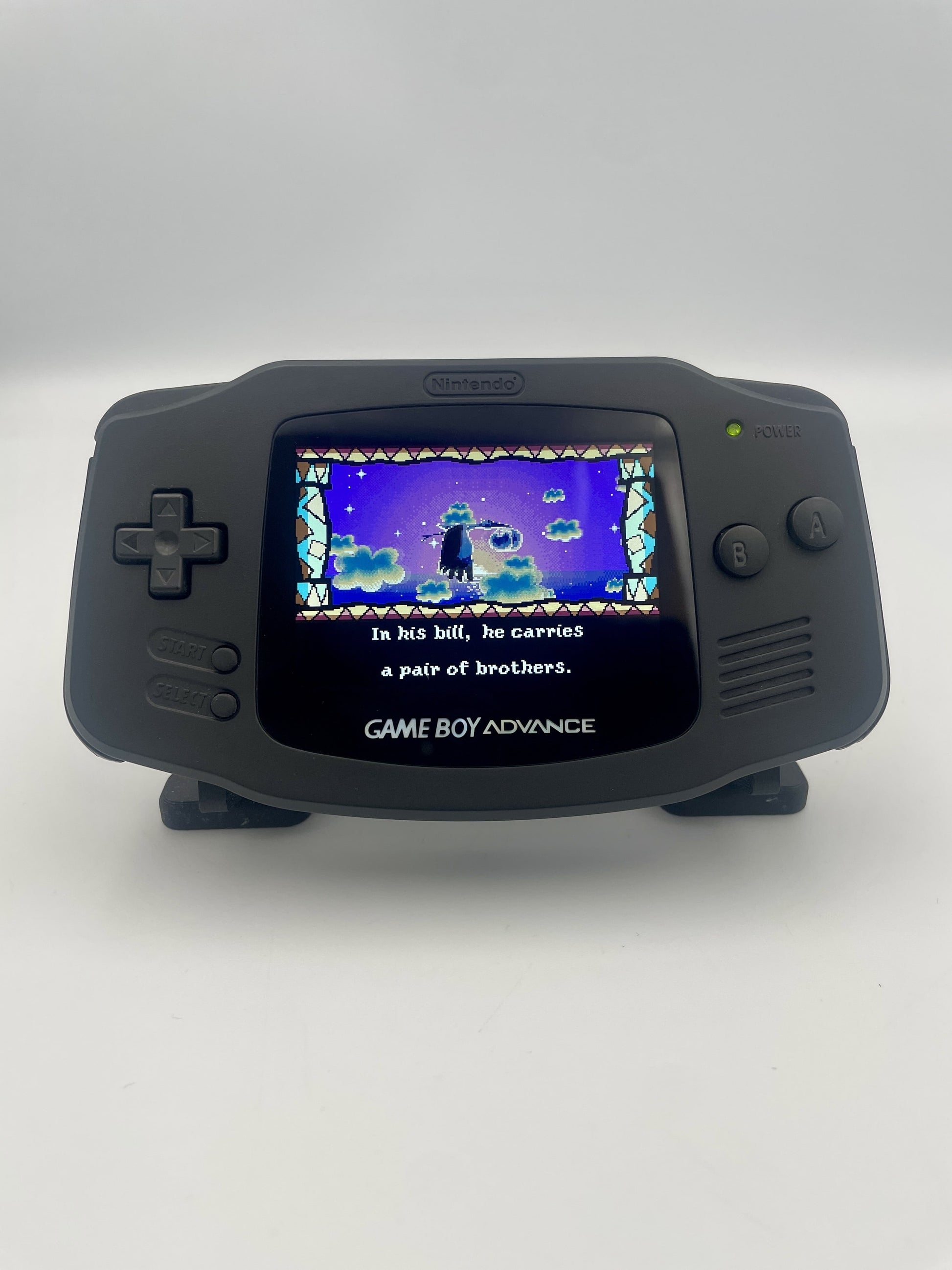 Black Game Boy Advance displaying a game on a white background