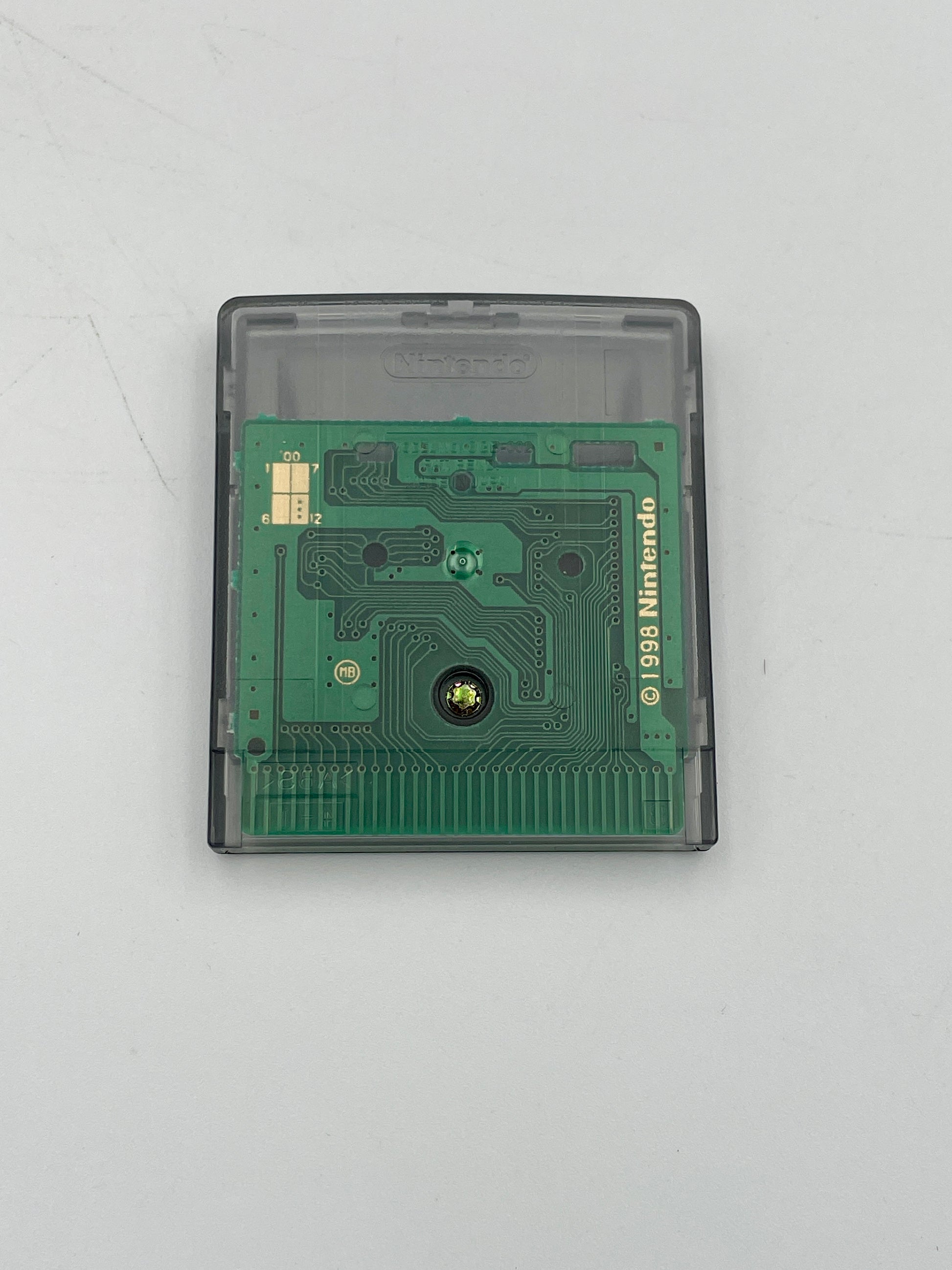 Green electronic circuit board in a clear casing on a light gray background