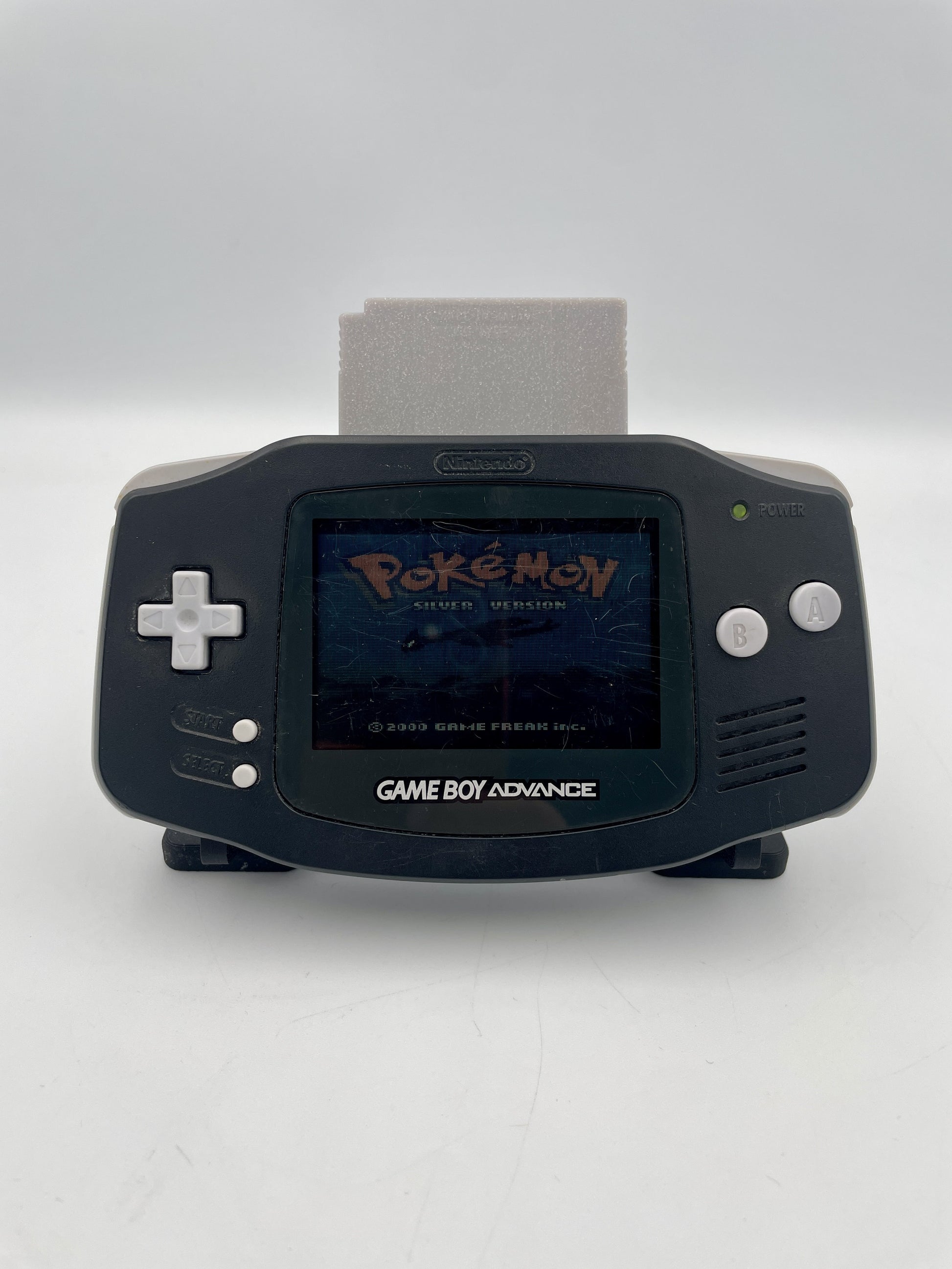 Black Game Boy Advance with a 'Pokémon' game displayed on the screen against a white background