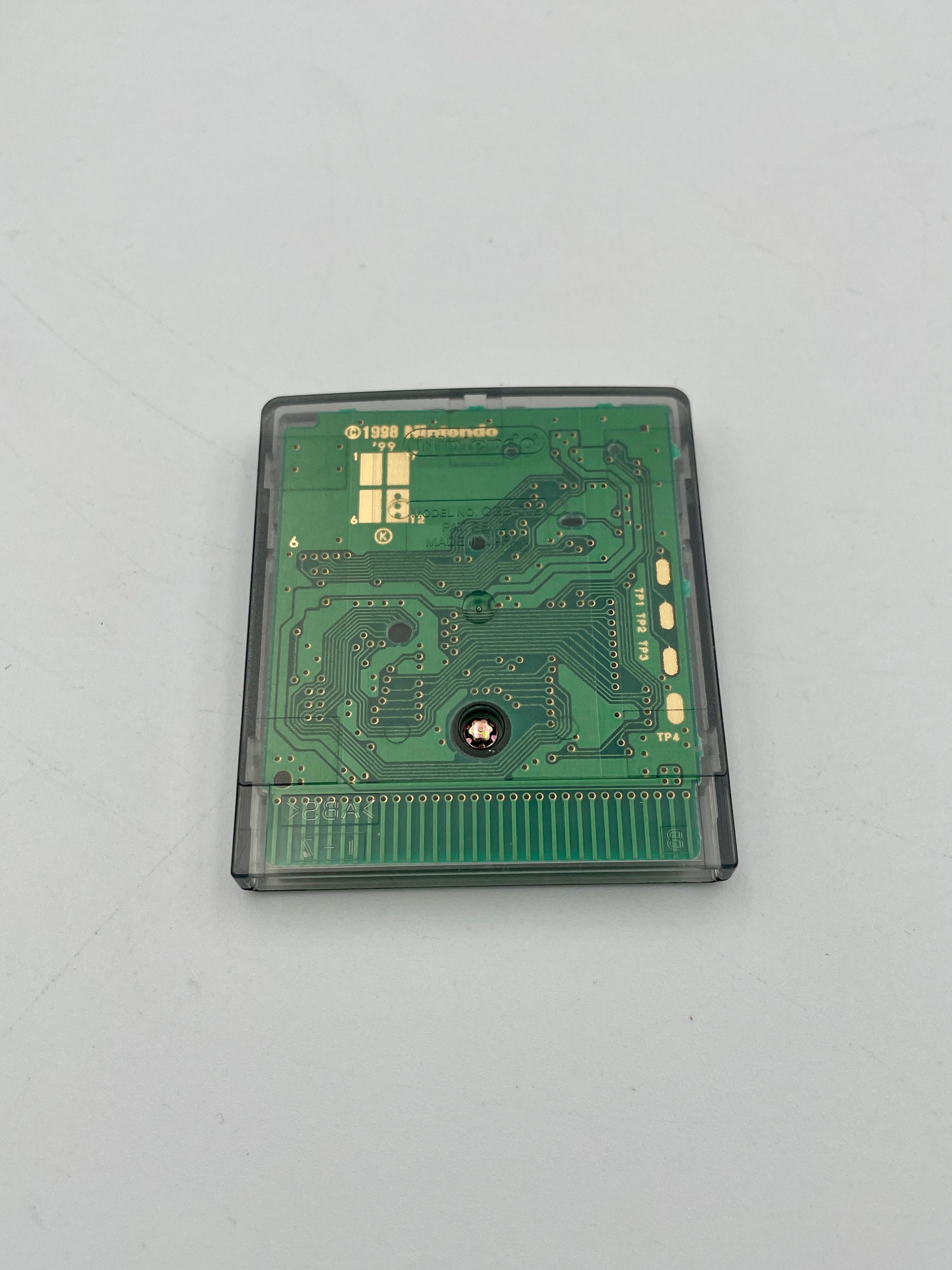 Green circuit board in a cartridge case on a light gray background