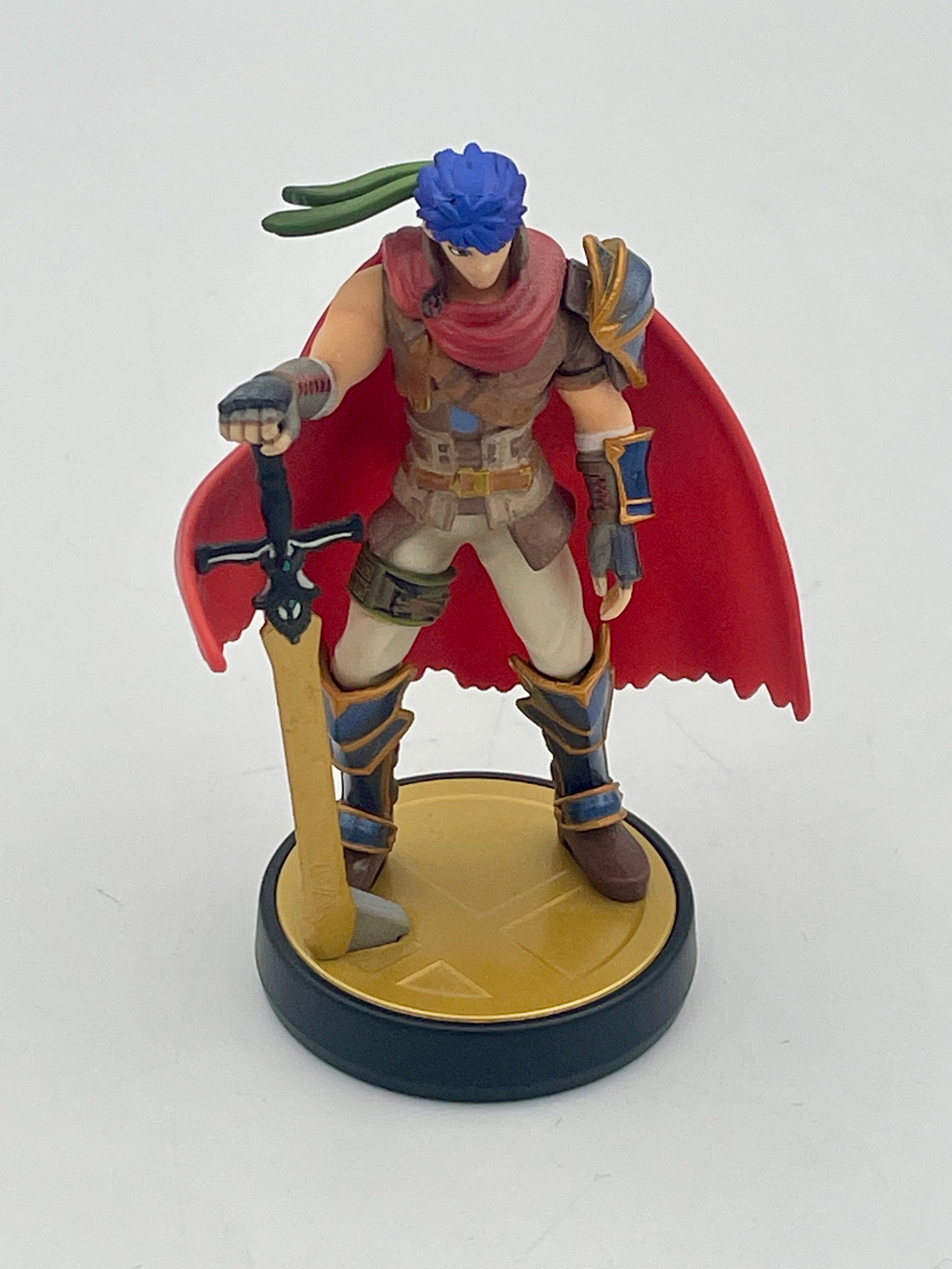 Figurine of a warrior with a red cape and blue hair on a white background