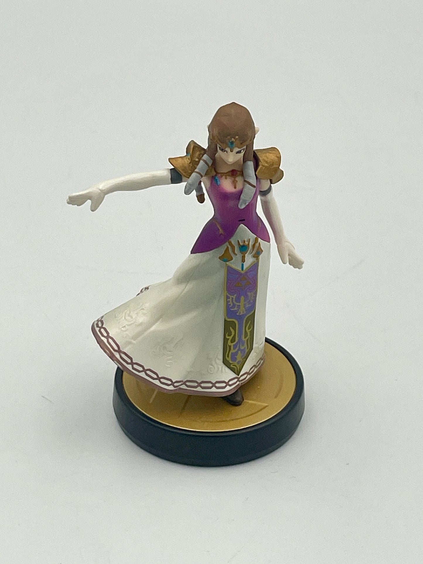 Figurine of a character in a purple and white dress on a round base against a white background